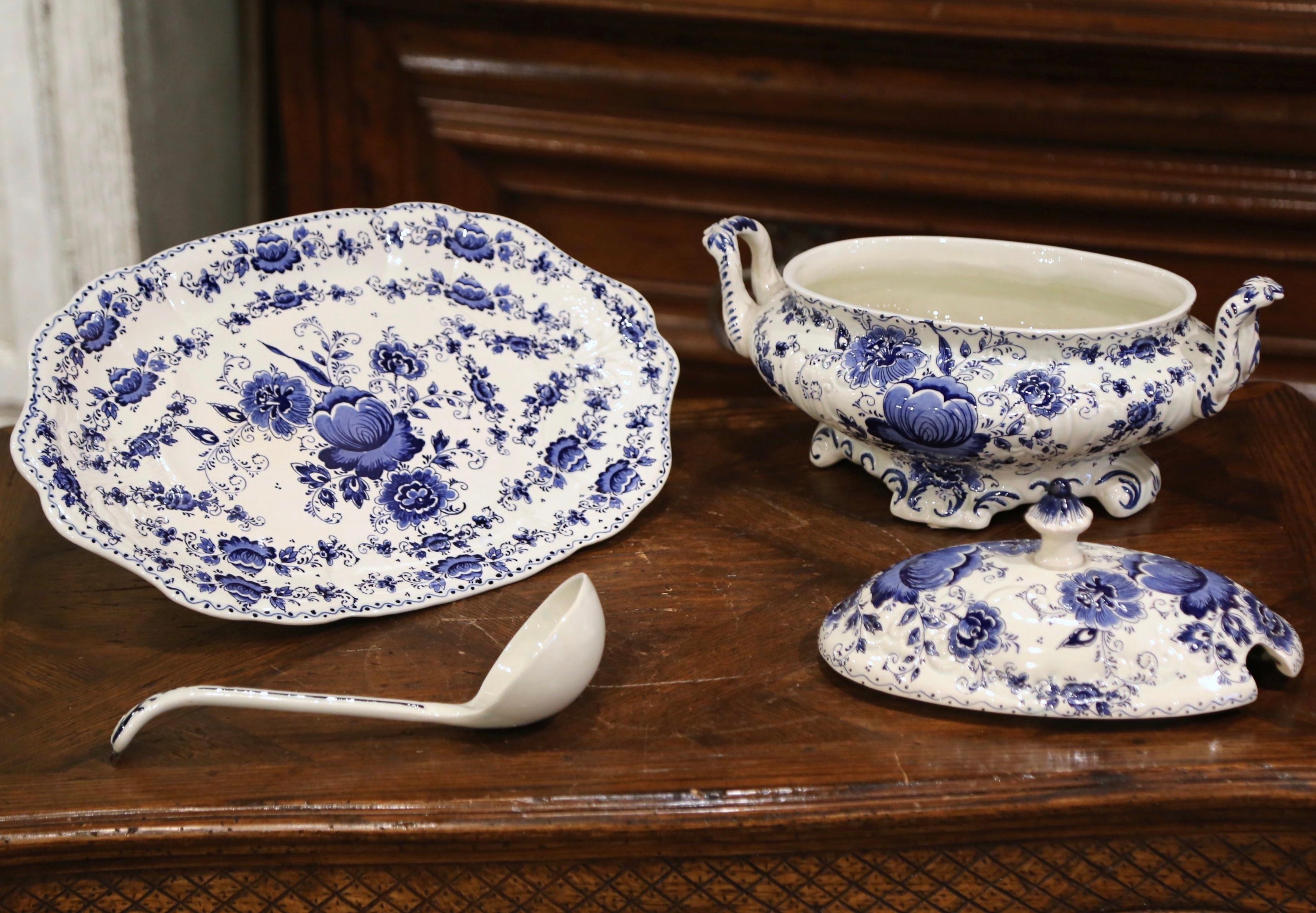 Decorate a dining table with this elegant antique faience dish. Crafted in Holland circa 1950, the centerpiece includes an oval tureen with side handles and open lid, the oval under platter with scalloped edges, and the soup ladle; all pieces are