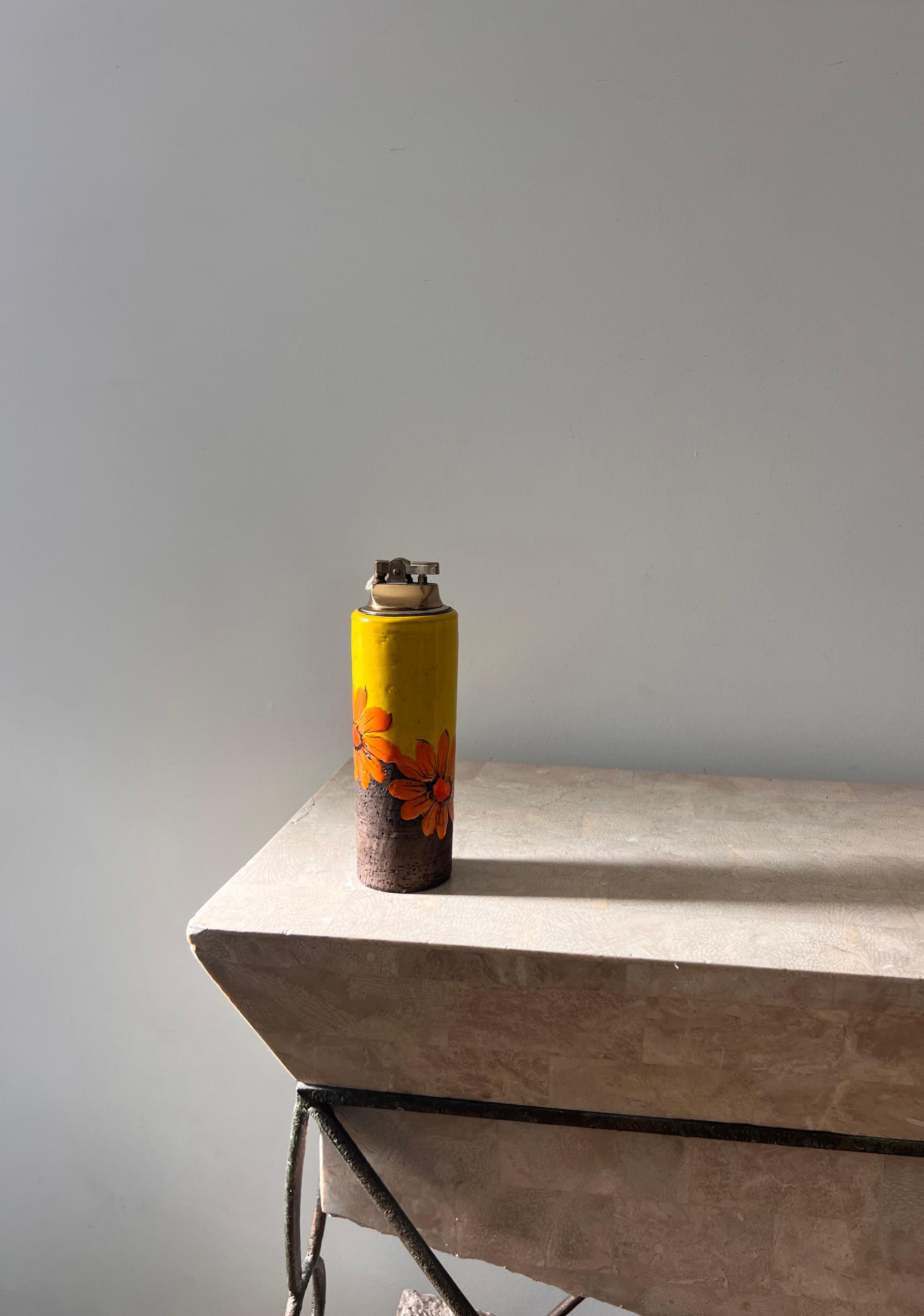 A vintage Italian mid century modern ceramic table lighter by Aldo Londi for Bitossi, imported by Rosenthal-Netter, 1960s. This unique lighter boasts tones of marigold, tangerine, and chocolate, as well as a vaguely psychedelic leaning motif