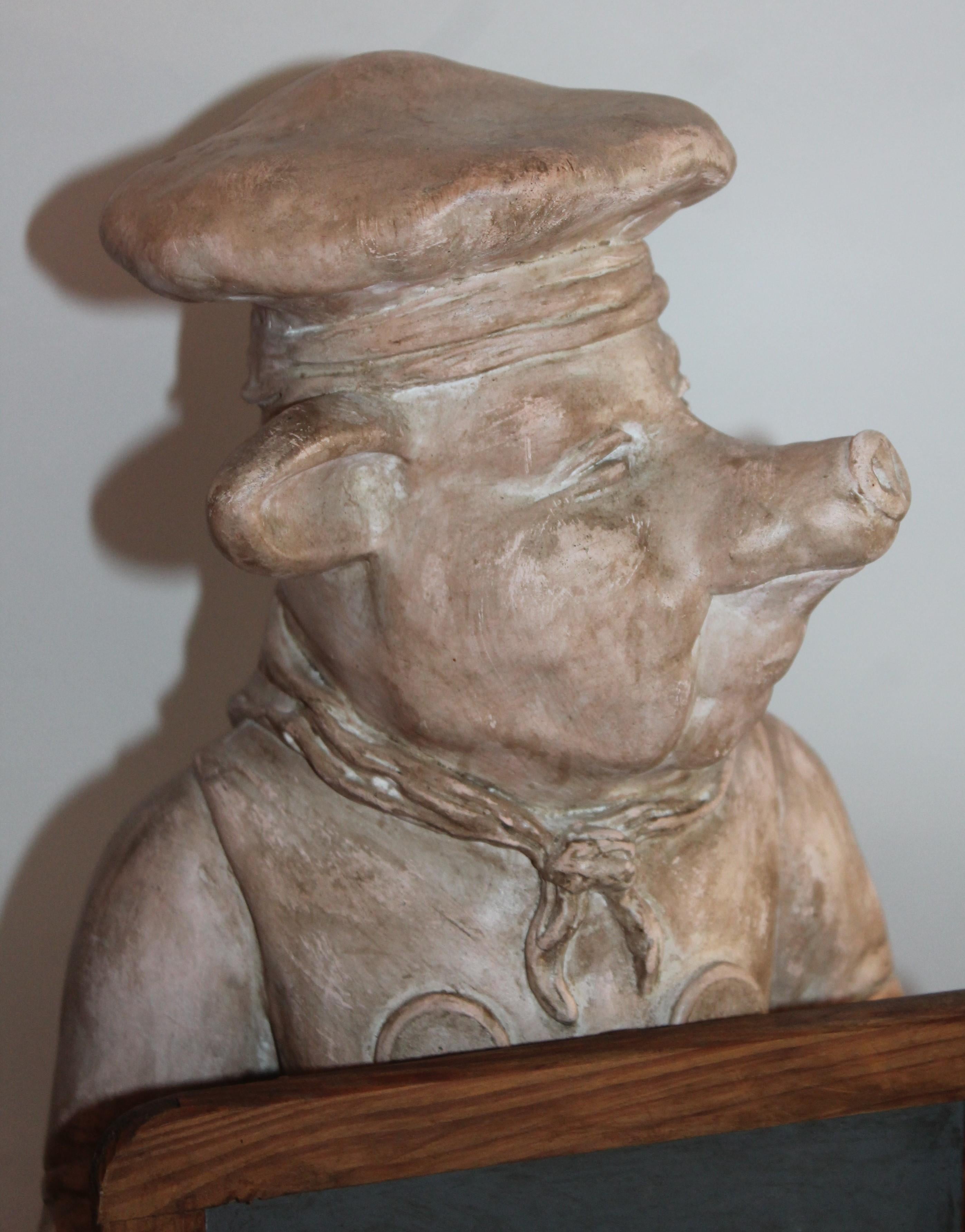 chef pig statue with chalkboard