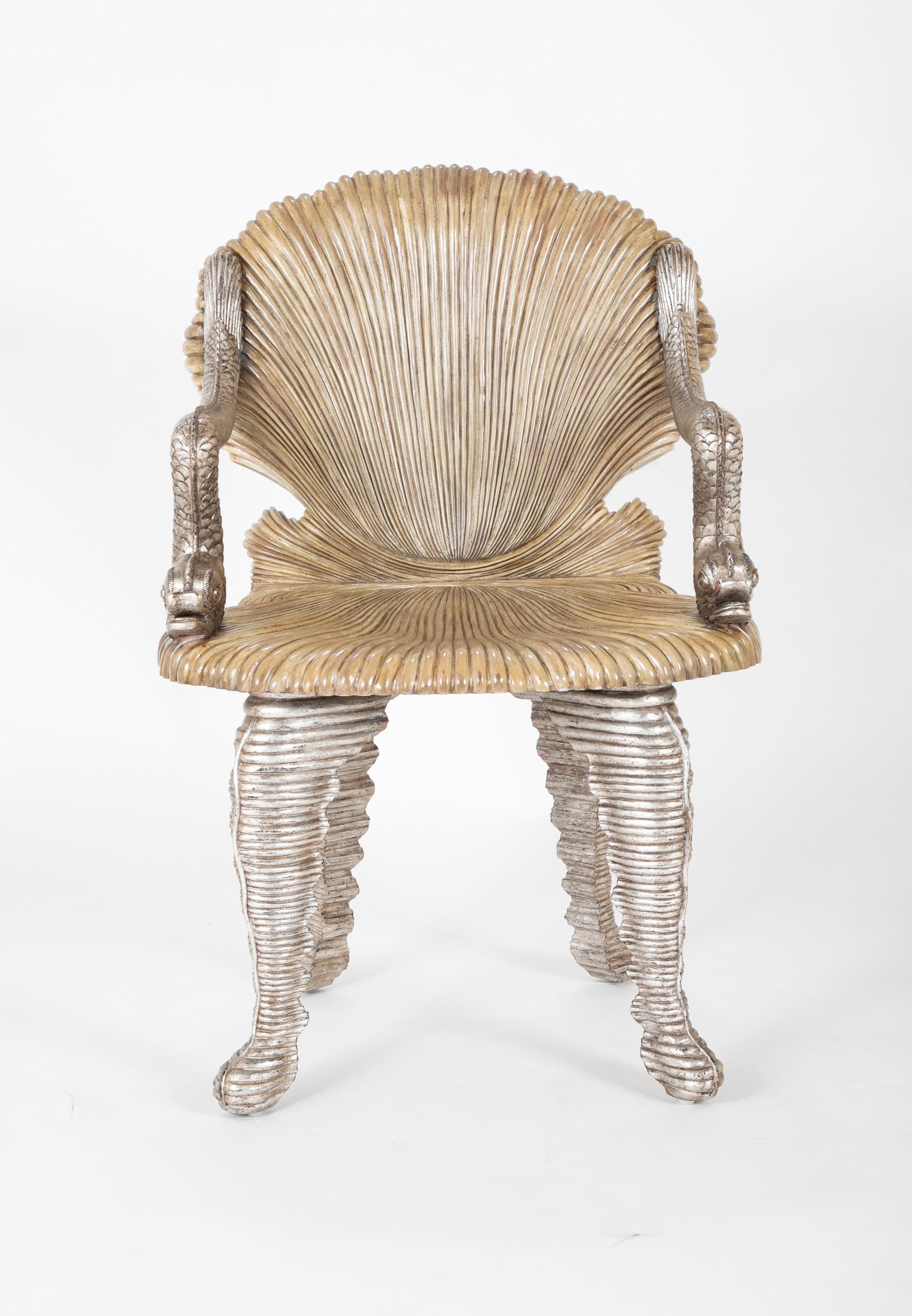 A midcentury painted and silver gilt Grotto chair with hand carved dolphin legs and arms.