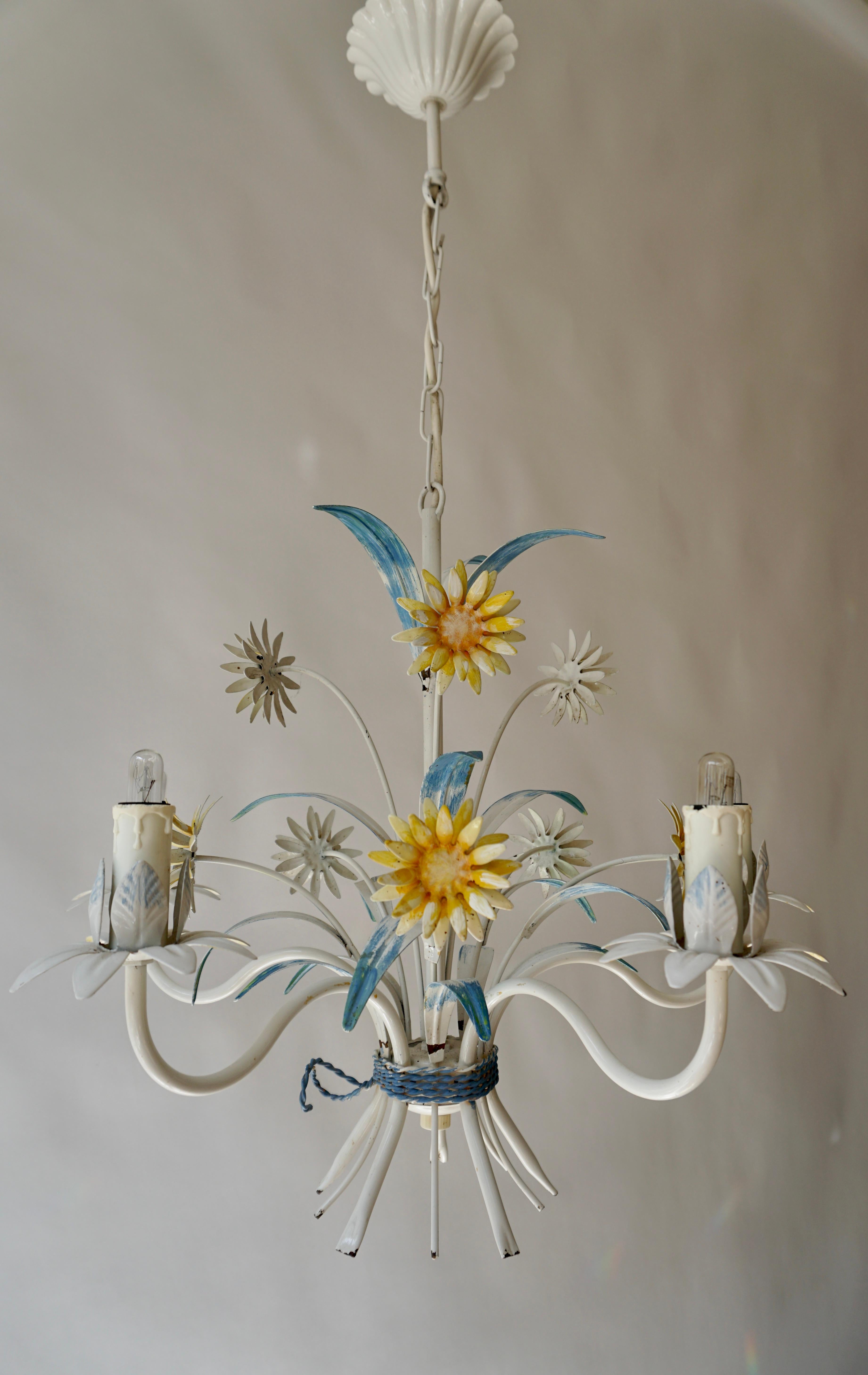 A vintage painted tôle light fixture from the mid 20th century, with five lights. Created during the midcentury period, this light fixture attracts our attention with its yellow painted flowers and blue leaves. This chandelier will bring a whimsical