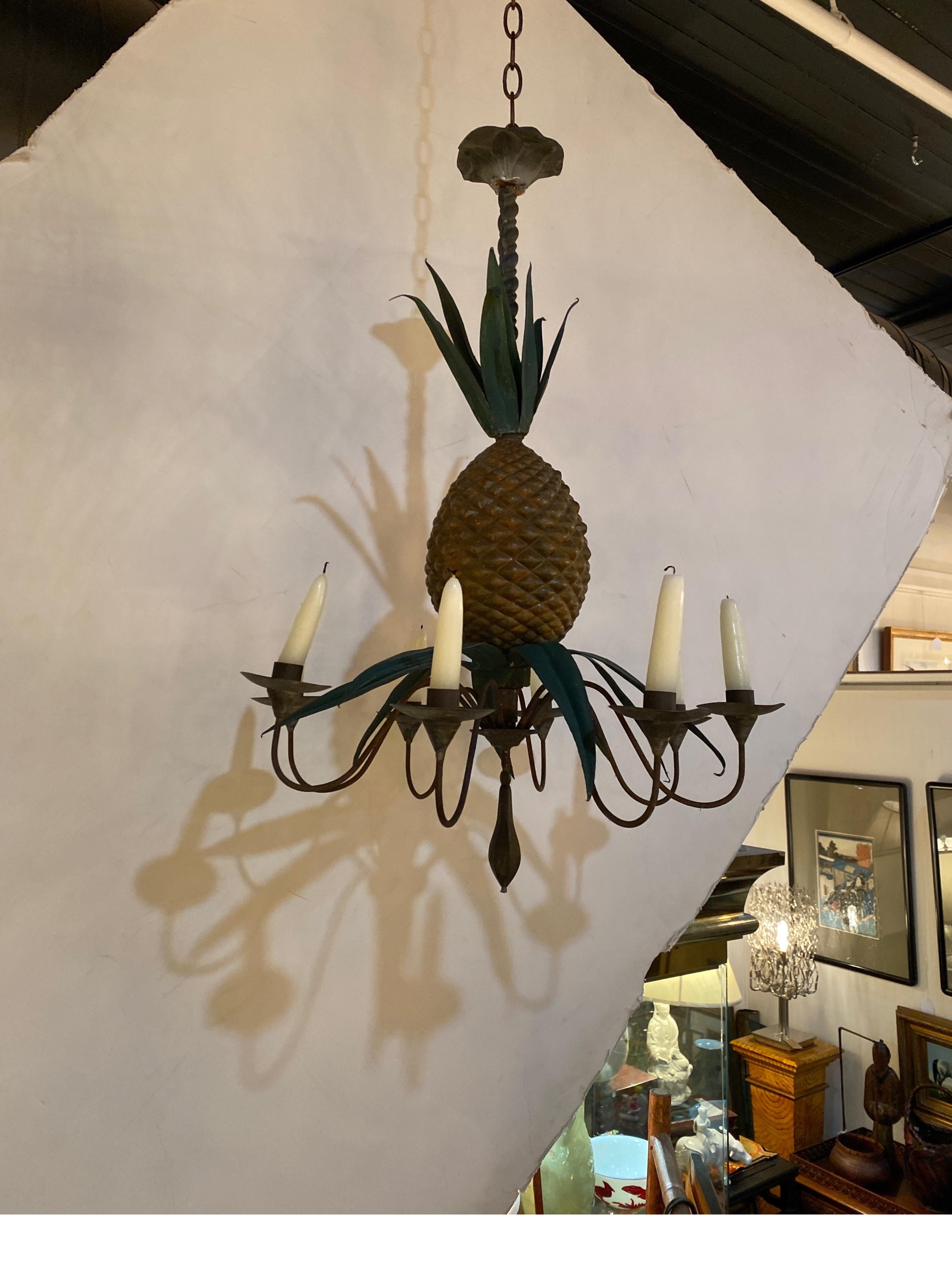 A whimsical hand painted tole and zinc 8 arm chandelier for candles. The chandelier in the form of a pineapple with leaves. Mid 20th century.