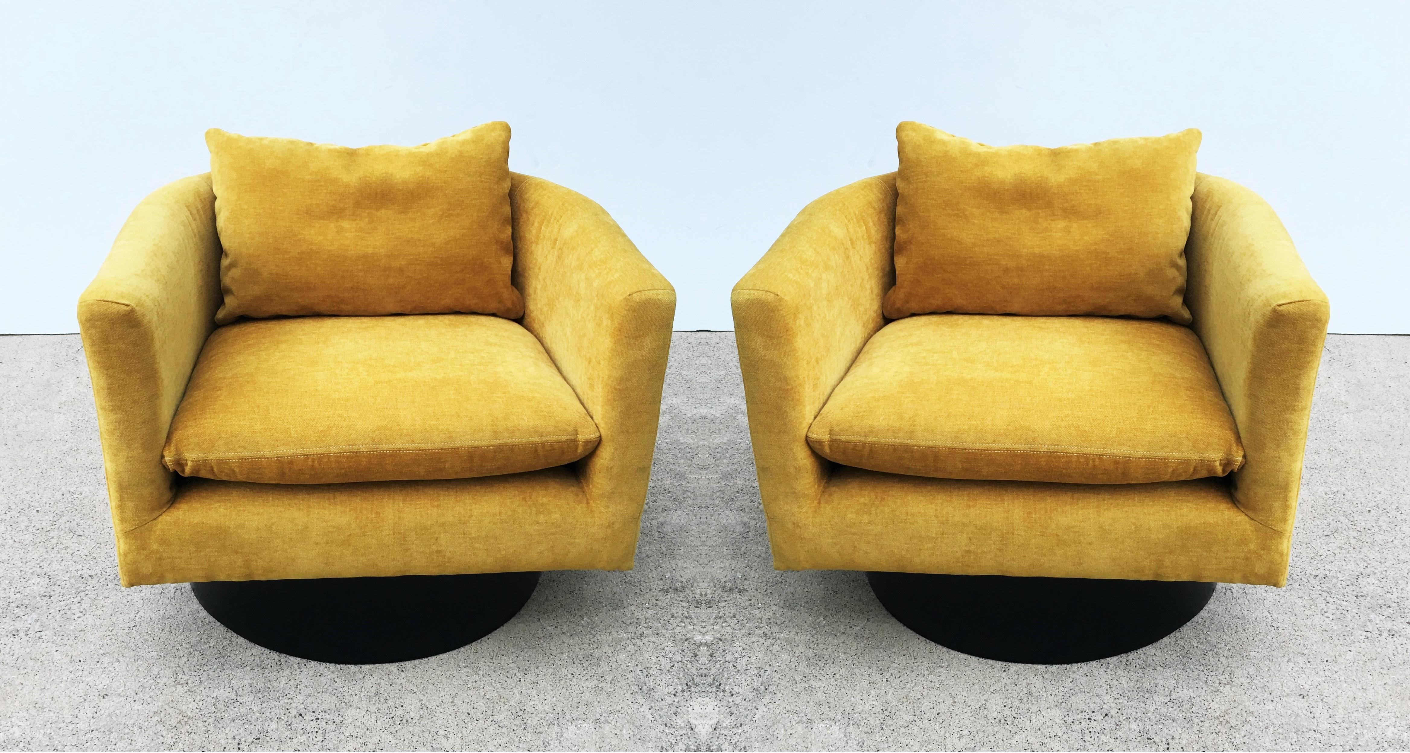Handsome pair of very unusual swivel chairs designed by Milo Baughman, circa 1960s. Completely restored, newly upholstered in a stunning yellow fabric and resting on high ebonized bases. These bold club/lounge chairs make a colorful statement in any
