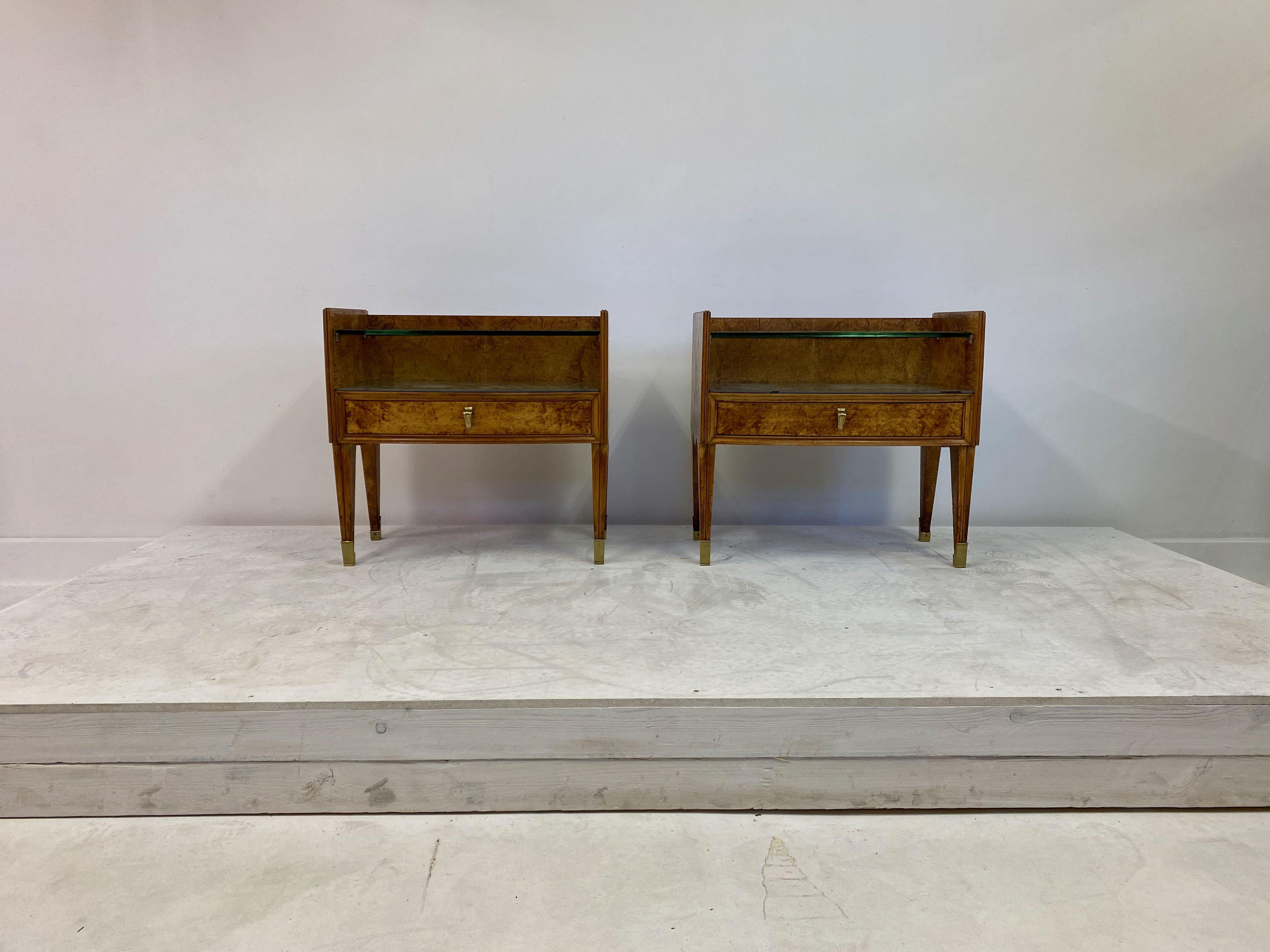 Pair of bedside tables

Burl wood

Striking grain

Grey glass top which can be removed to show grain underneath (see photos)

Thick glass shelf

Brass feet

Brass handles

Quality brass details

Italy 1950s.
  