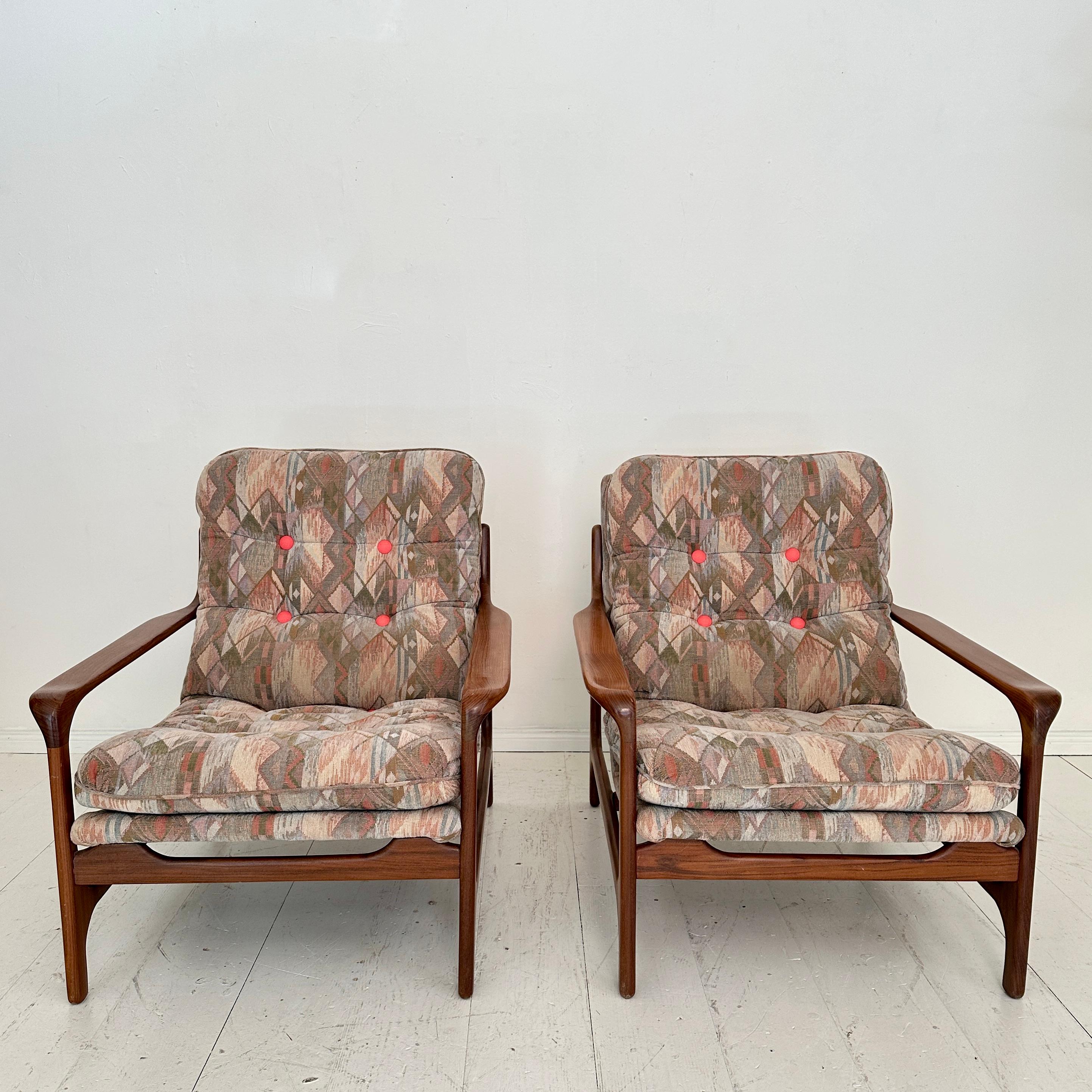 Questa elegante coppia di poltrone di metà secolo, realizzata intorno al 1960, riflette il raffinato modernismo caratteristico dell'estetica di Eugen Schmidt. Realizzate in teak con una bella venatura, le sedie presentano linee pulite e organiche e