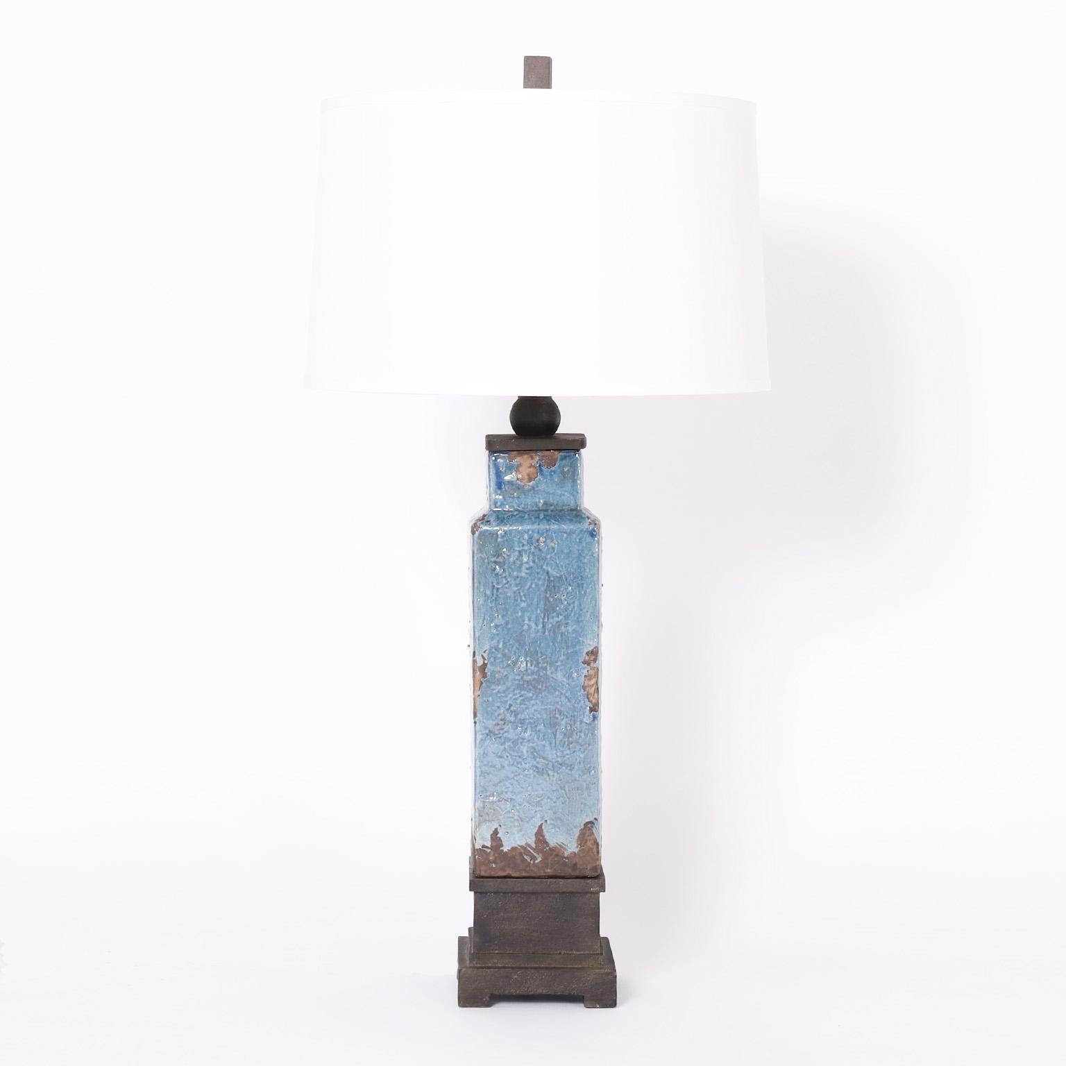 Chic pair of vintage table lamps crafted in terracotta in a sleek simple form decorated with a contrived distressed blue glaze, and having a modern yet classic cap and base in painted metal.