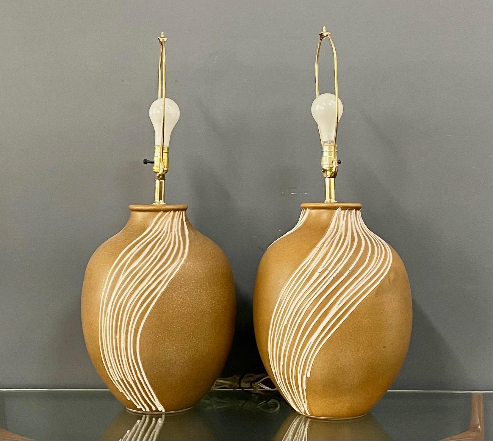 Large ceramic lamps that have a wave design in applied white stripes in a wave pattern.