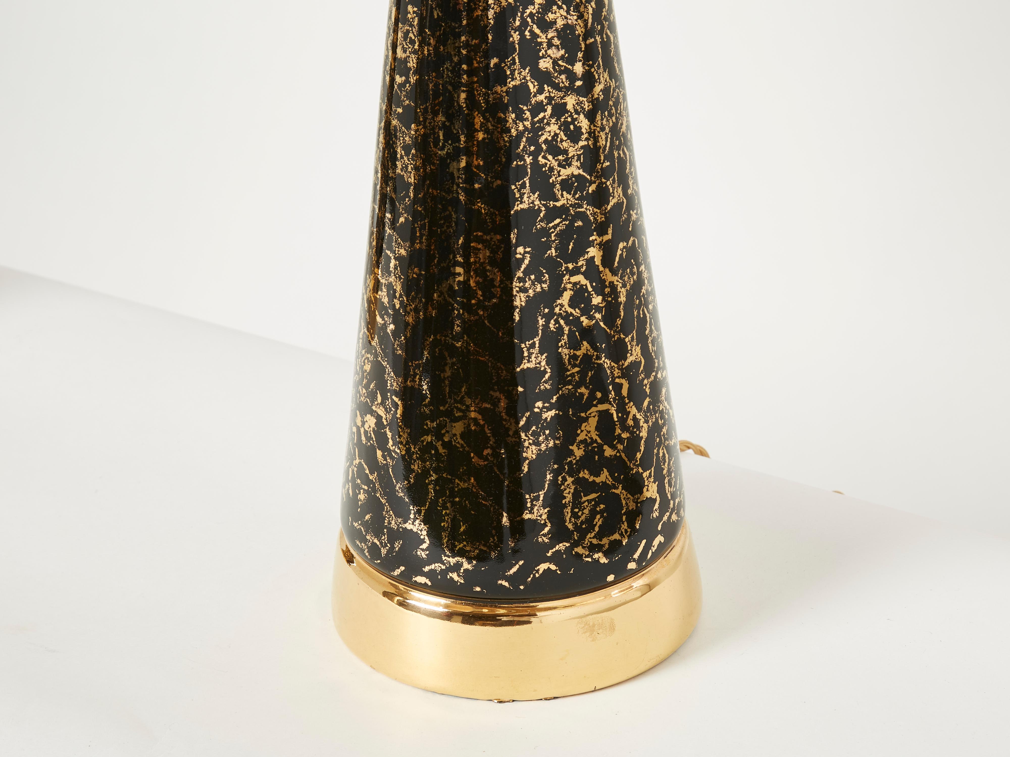 All understated luxury, this pair of 1970s French table lamps boast the exquisite craftsmanship characteristic of mid-century french ceramics. Featuring elegantly rounded curves with distinguished brass feet, the black and gold ceramic subtly