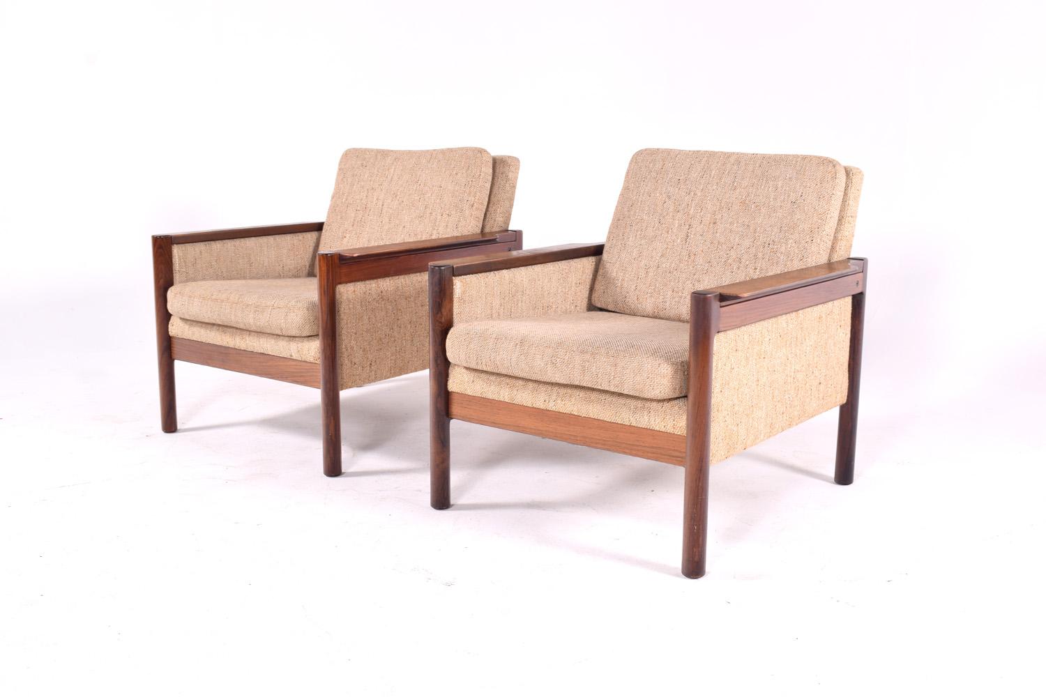 Designed by Illum Wikkelso in 1959 the Capella series was produced by Danish furniture maker Niels Eilersen A/S from the 1960s.
They are made from solid rosewood frames with interlocking joints on the arms. Each chair compromises of two separate