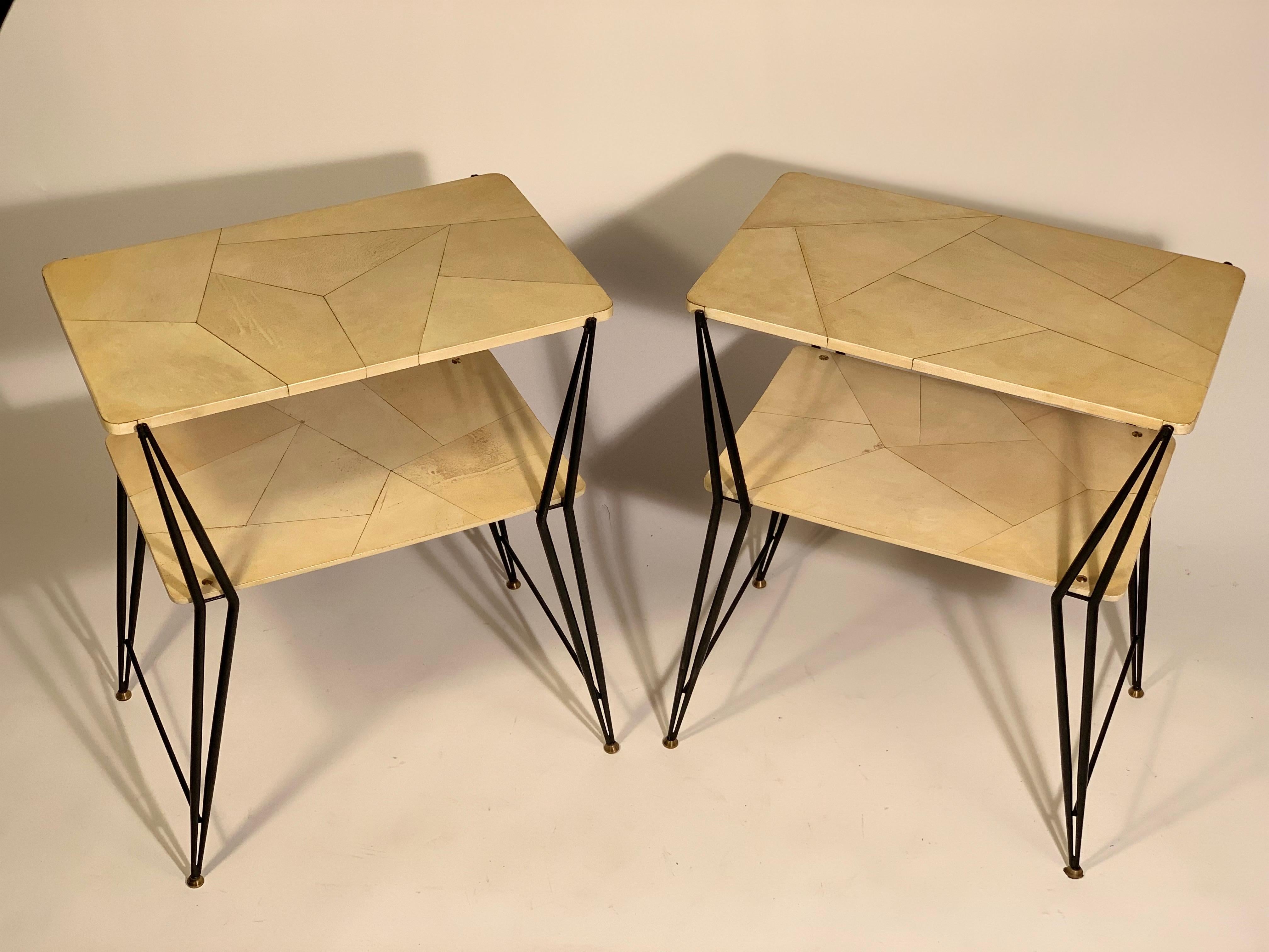 Pair of rectangular Italian coffee tables or side tables with double top, structure in thin black lacquered metal tubular with brass details, feet and buttons.
The two tops are covered in parchment inlaid with geometric segments that form an