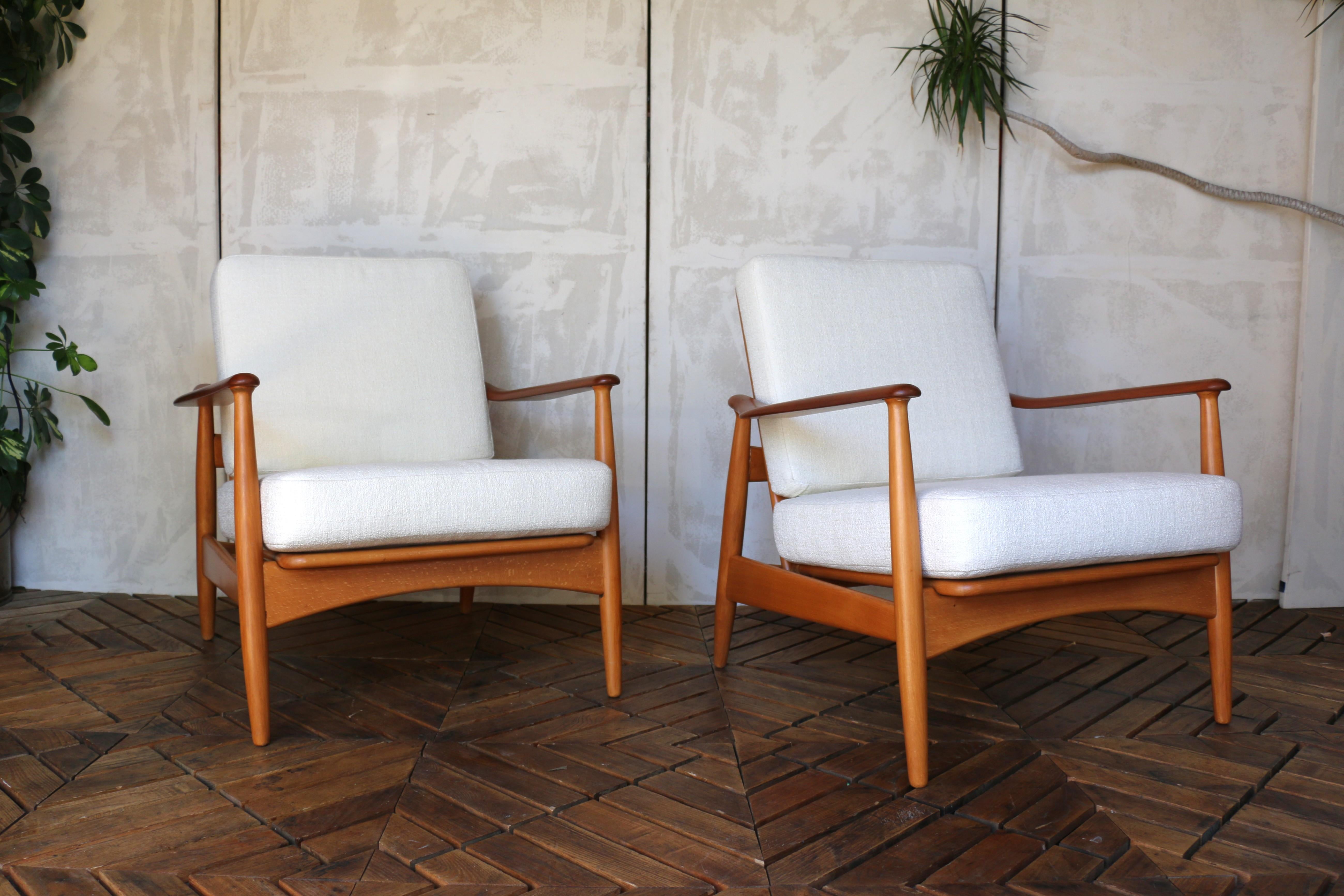 Questa splendida coppia di sedie da salotto di Wood Wood del Medioevo è caratterizzata da un raffinato mix di legno di teak e faggio, che mette in mostra le linee scultoree e l'eleganza organica dei celebri design di Arne Vodder (queste sedie non