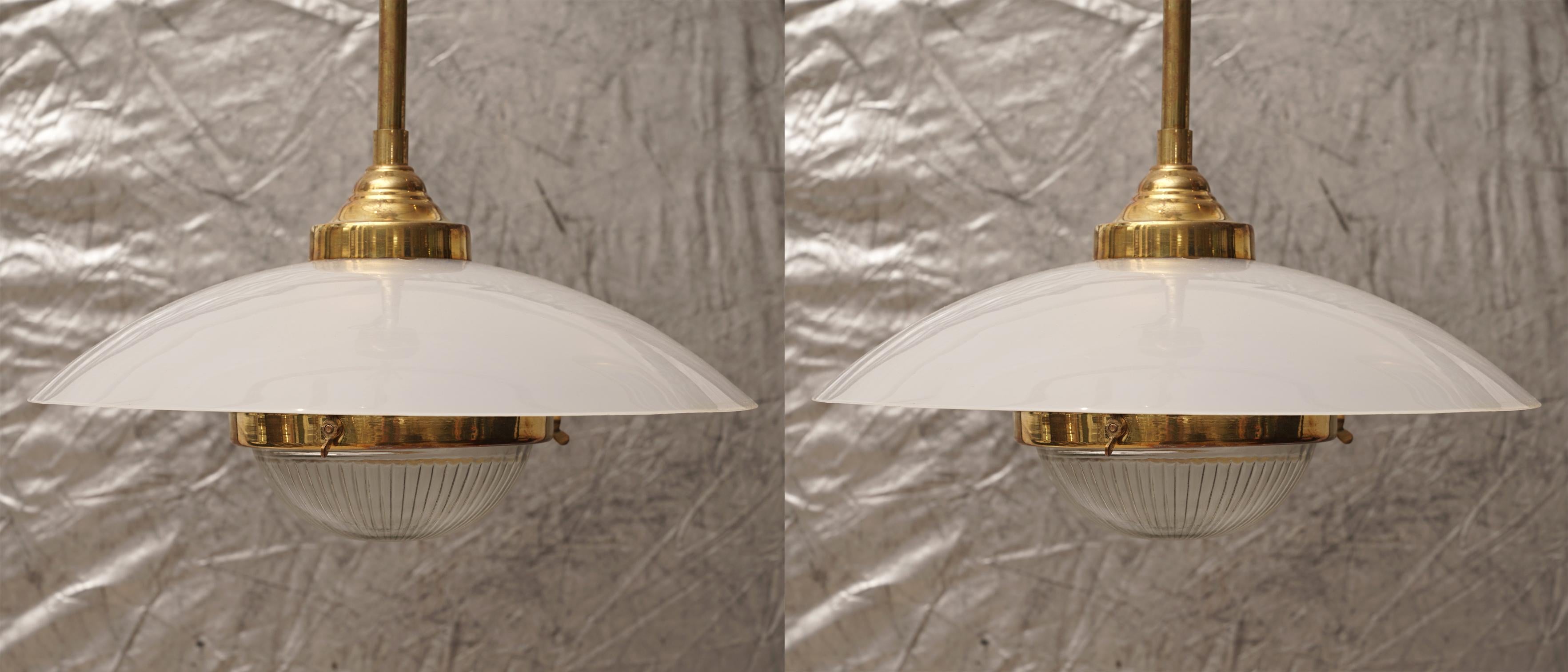 Pair of midcentury brass pendant lights with Lucite shade and textured glass lens. Takes a standard base light bulb and have been rewired for American use.