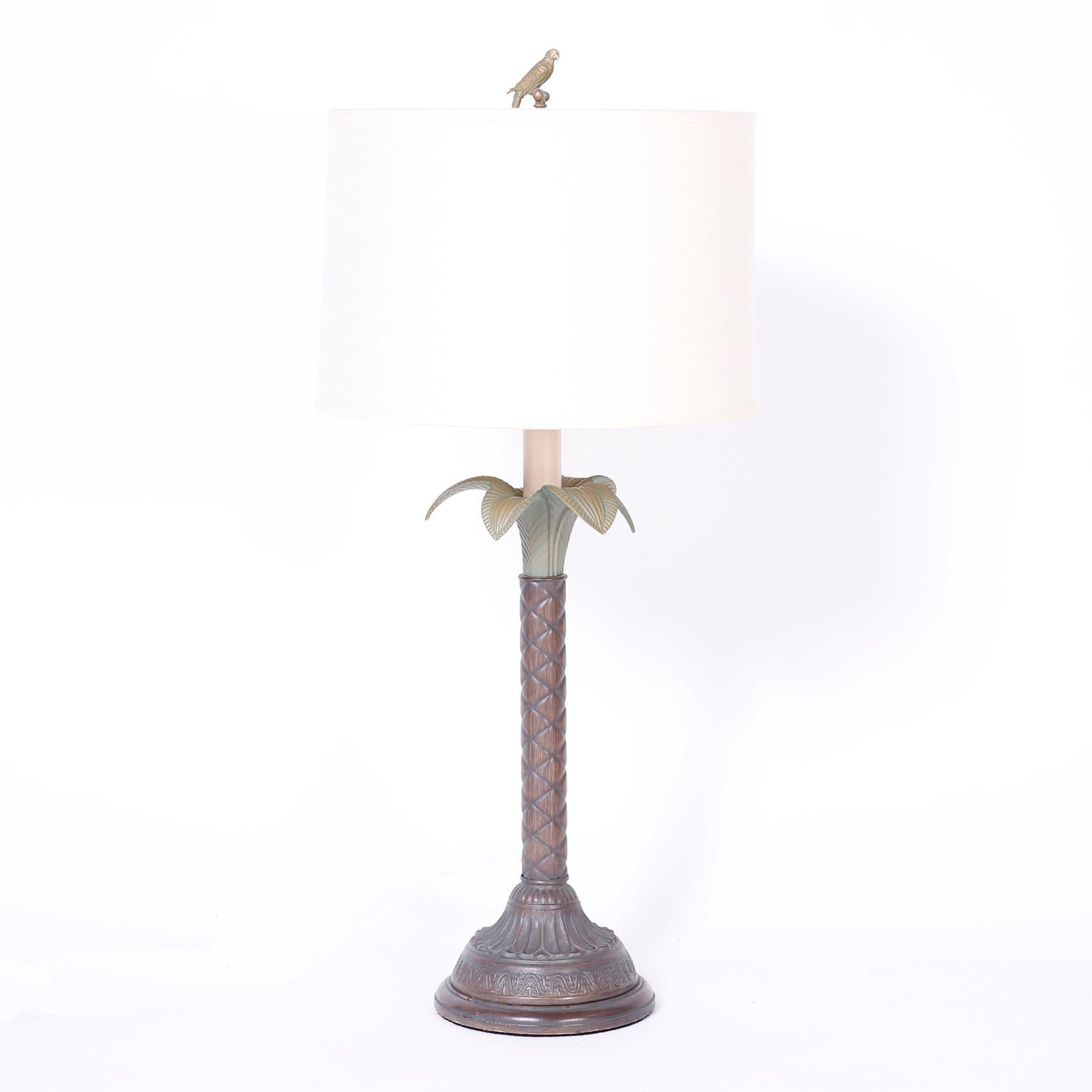 Lofty pair of midcentury tole or painted metal table lamps with cast brass bird finials over a stylized palm trees and round wood bases.