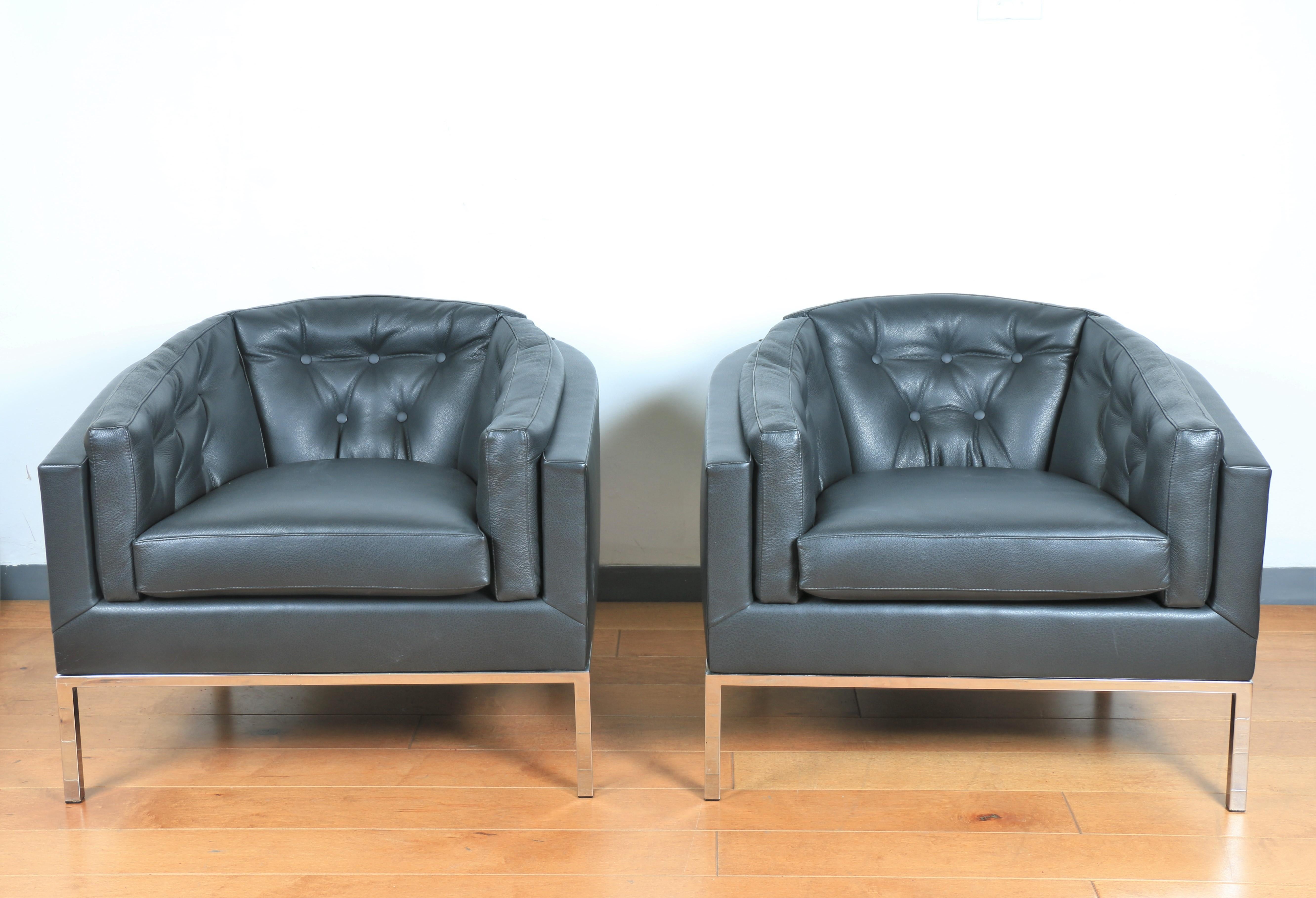 Gorgeous pair of leather tufted reupholstered lounge chairs with steel bases.. Excellent comfortable condition. Both are strong and sturdy. Great for any mid-century home.
 