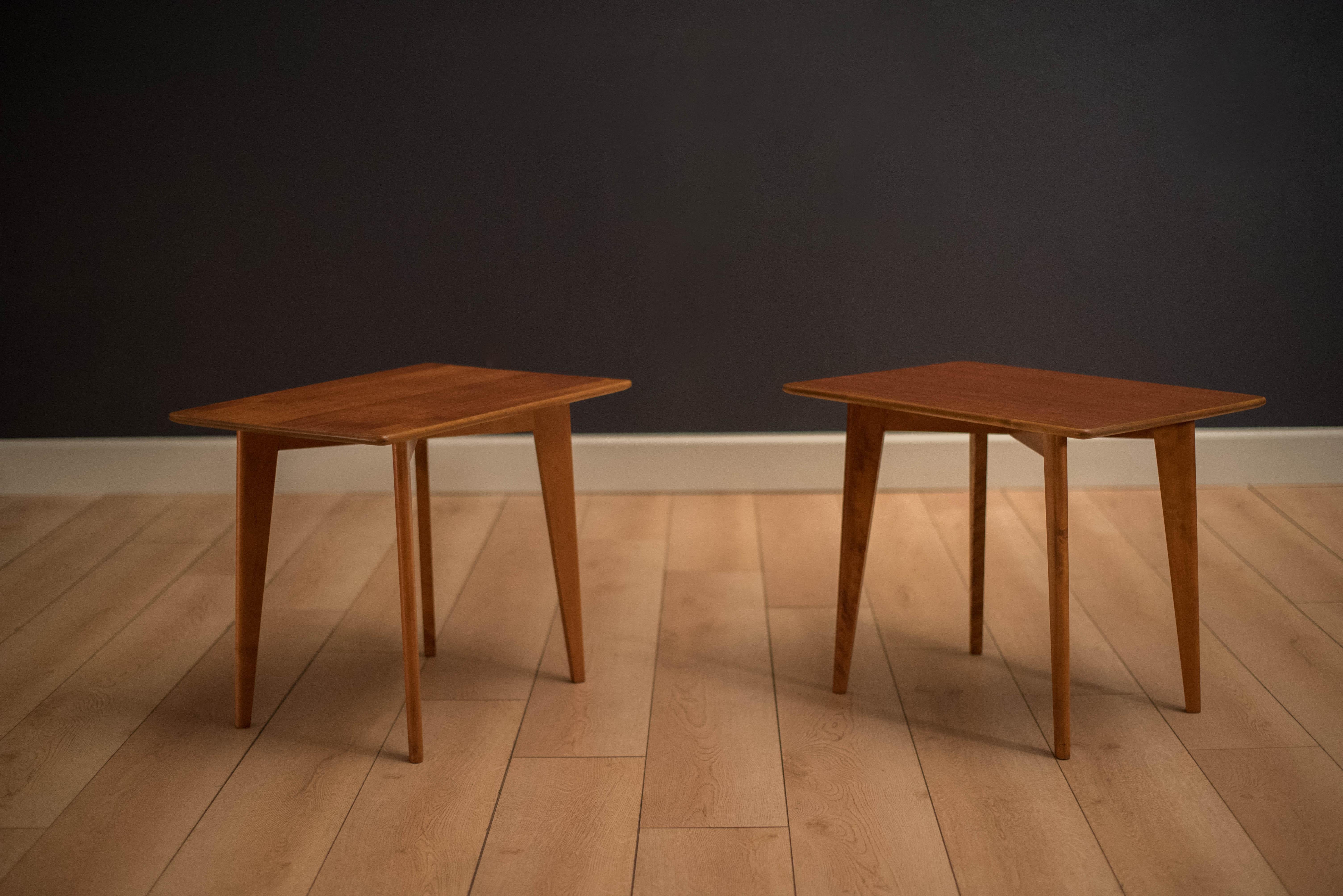 Mid Century matching pair of side tables manufactured by DUX in teak. This set features splayed legs and a rectangular top. Price is for the pair.