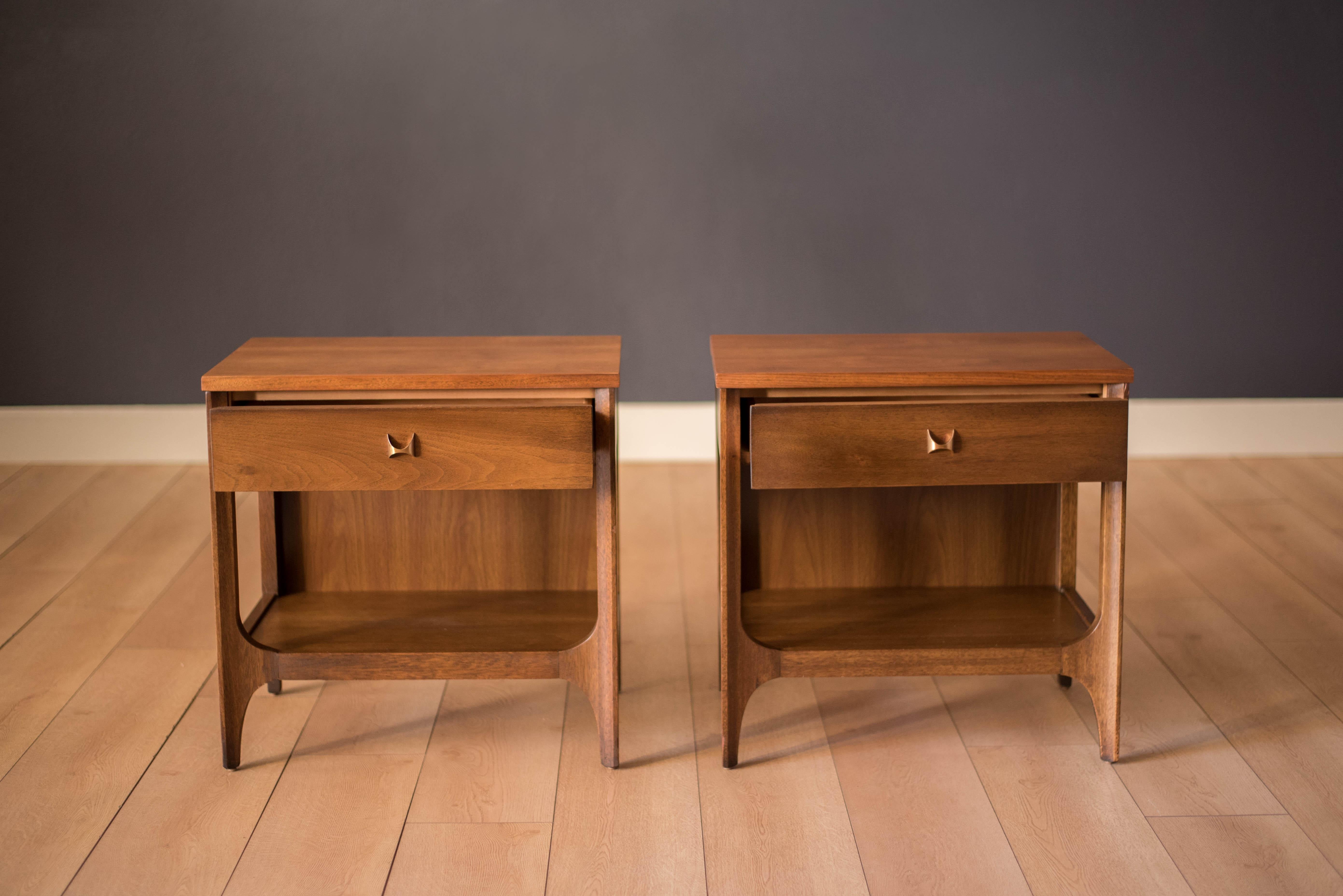 Vintage pair of Brasilia nightstands manufactured by Broyhill Premier, circa 1960s in walnut. This set is accessorized with the line's signature arches and handles reminiscent of Oscar Niemeyer's iconic architectural designs in Brazil. Features one