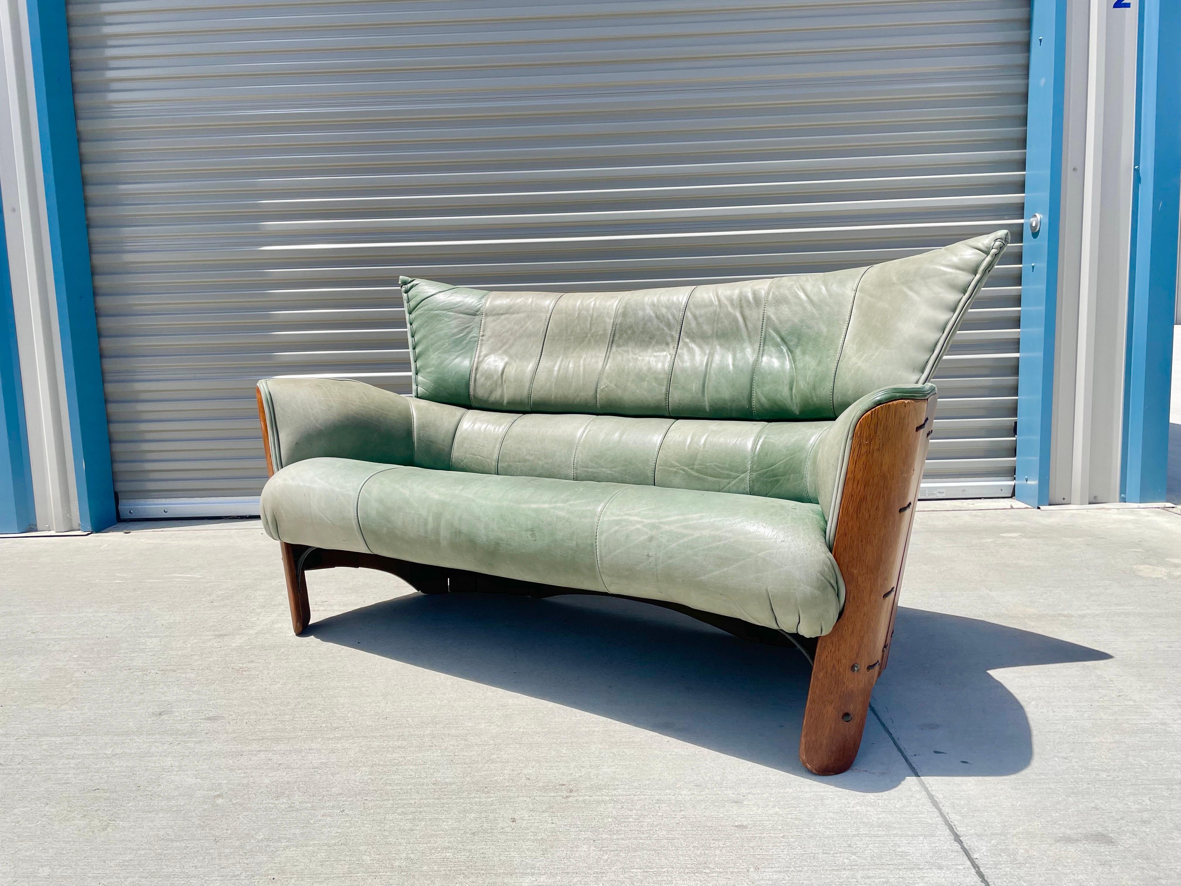 Midcentury palmwood and leather sofa/loveseat design by Pacific Green. This beautiful piece can be used as a sofa or as a loveseat making it pretty unique. It features a wrapped palmwood finish around the sofa with leather binding holding it