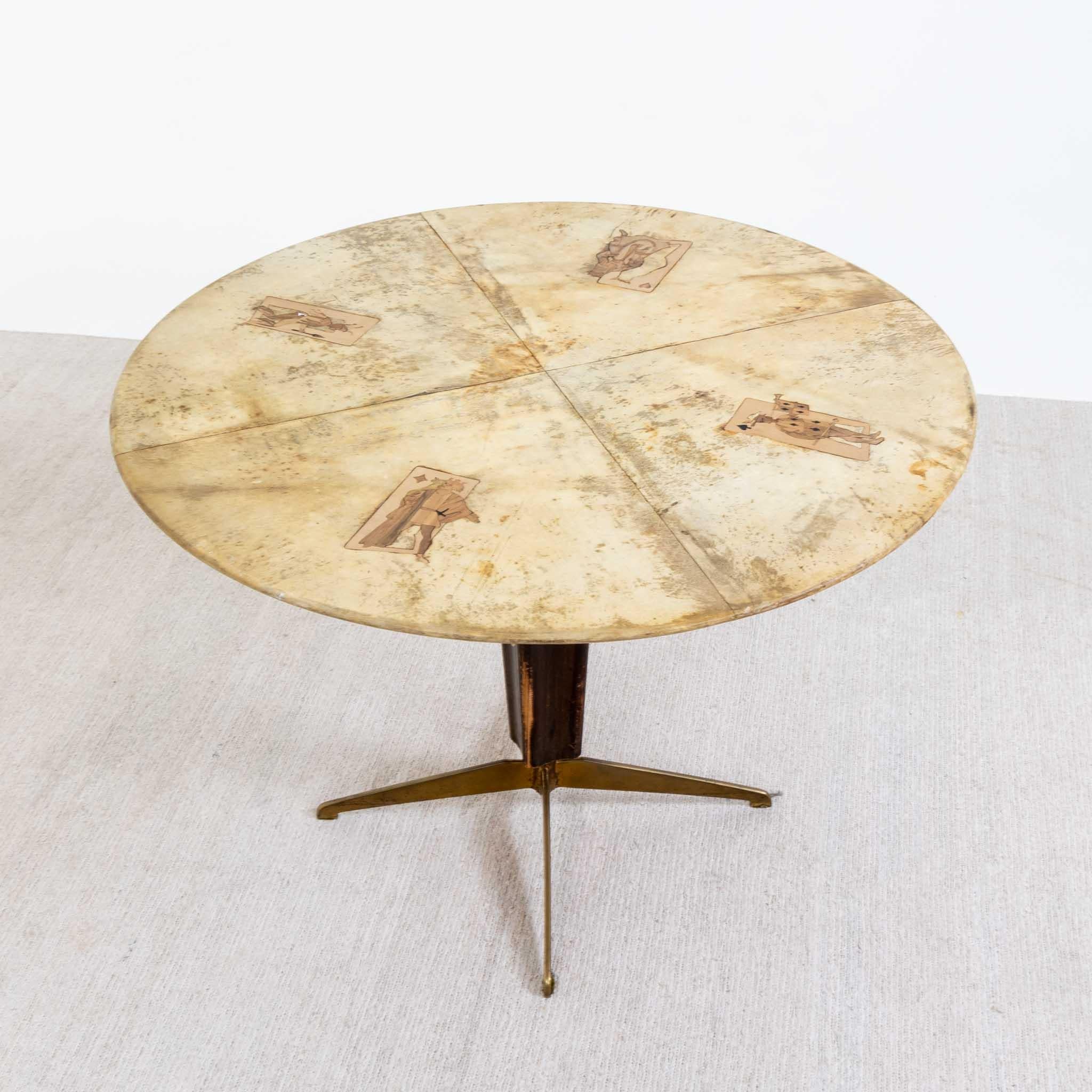 Parchment center table with wood marquetry inlay in a playing card motif. 
Brass base with mahogany wood support.