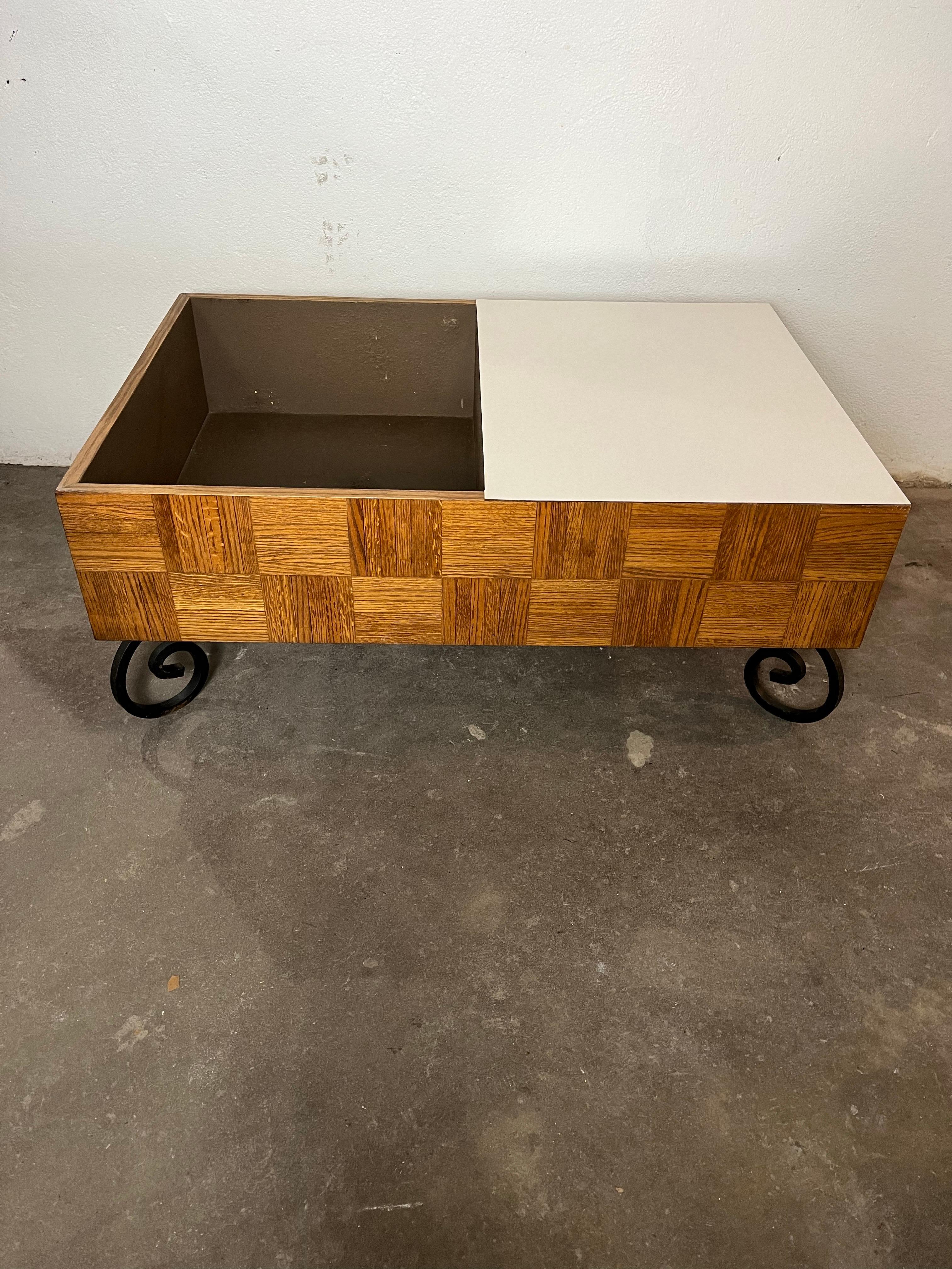 Table basse unique en chêne parqueté avec surface en formica blanc. Compartiment de rangement ouvert. Il repose sur des pieds en fer forgé à volutes. Magnifique chêne riche avec un motif de patchwork alterné. Très lourd.
En bordure de route vers