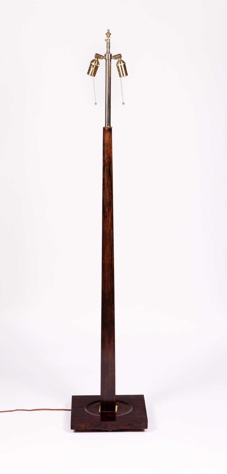 Lampada da terra a colonna affusolata di metà secolo composta da un unico pezzo di noce massiccio ebanizzato con ferramenta in ottone. Ricablata con cavo di seta e doppie prese.