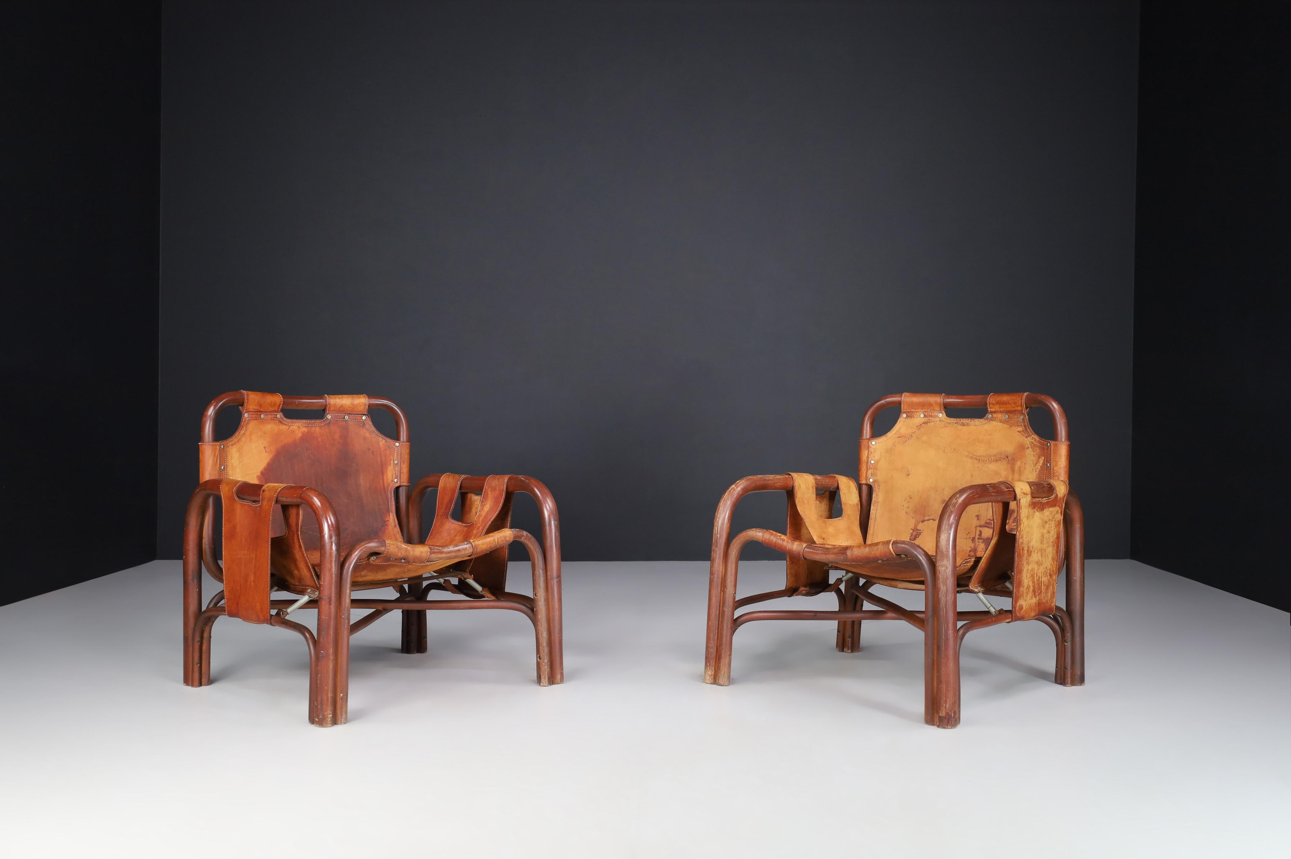 Mid-century patinated leather and rattan lounge chairs by Tito Agnoli Italy, the 1960s.

Rare and unique pair of Italian Mid-Century Modern rattan and patinated leather Lounge chairs by the designer Tito Agnoli for Bonacina, Italy, 1960s. In