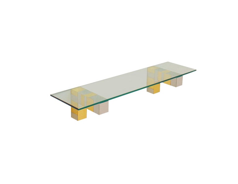 An incredible design, a cityscape wall shelf designed by Paul Evans in the 1970's. The set features Fine heavy construction with brass & chrome clad patchwork design. Includes two L shaped wall brackets, and heavy clear glass shelf. Price includes