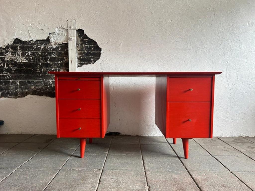 Bellissima scrivania a 5 cassetti a doppio piedistallo di Paul McCobb Group #1561 con finitura tinta rossa e pomelli in ottone in acero massiccio. La scrivania è in condizioni vintage e presenta segni di utilizzo e usura. Scrivania dal design molto