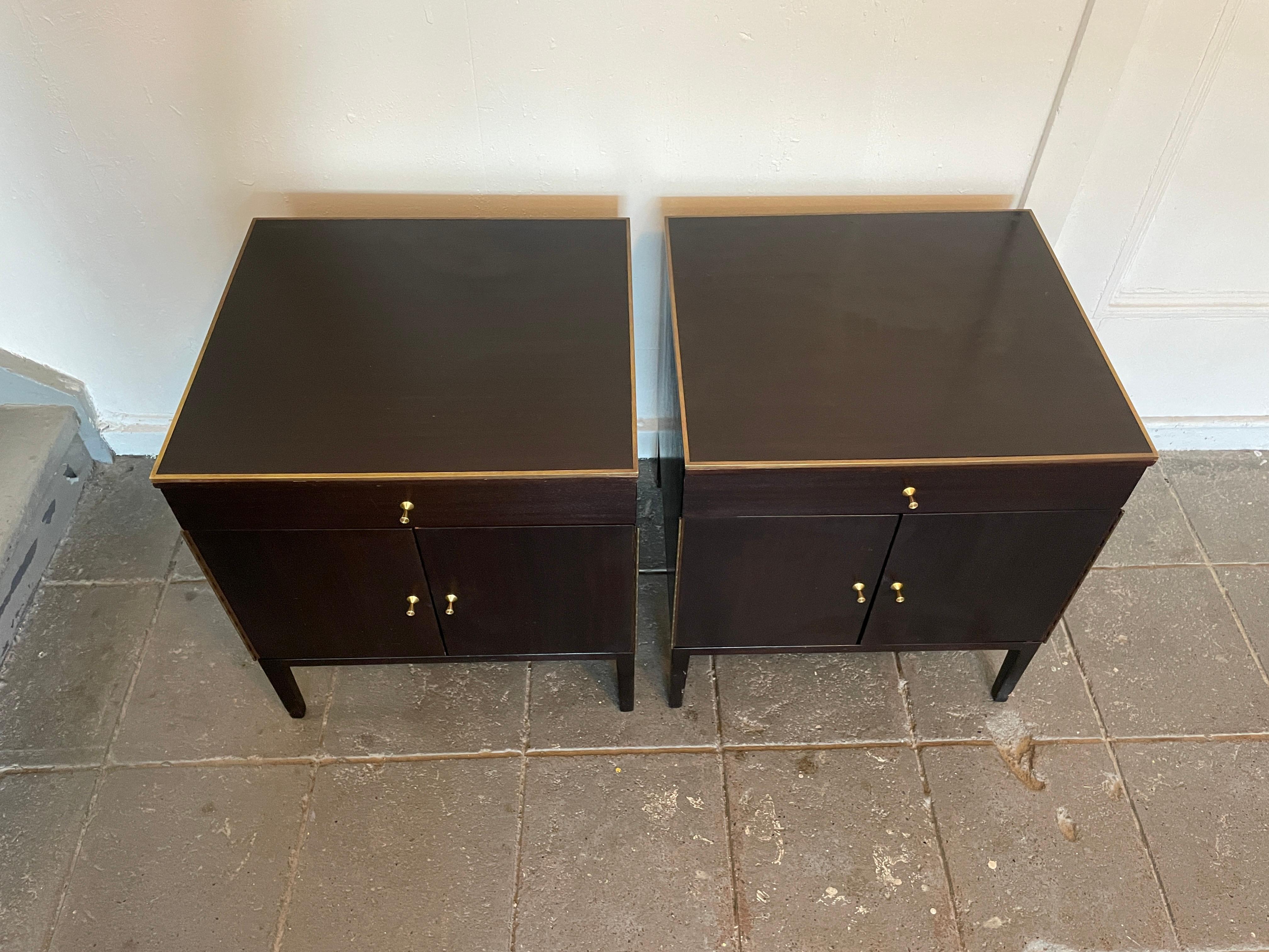 Magnifique paire de tables de nuit en acajou foncé Paul McCobb Production #7700 des années 1960 avec tiroirs doublés de cuir et garnitures en laiton. Un seul tiroir et un meuble inférieur avec une étagère réglable. Garniture supérieure, charnières
