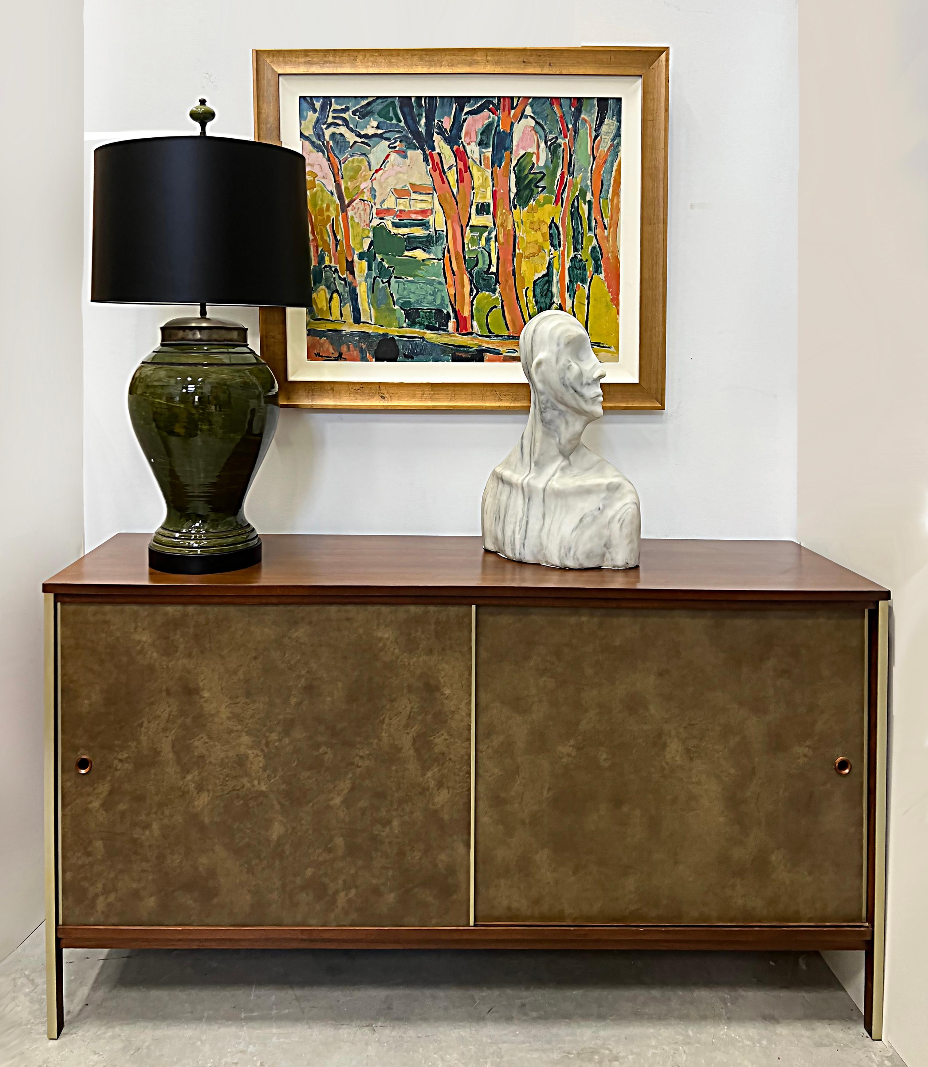 Mid-century Paul McCobb Calvin Line Leather Walnut Cabinet

Offered for sale is a Mid-Century Modern cabinet designed by the iconic designer Paul McCobb. This cabinet is for the high-end Calvin line with leather-clad doors and walnut construction.