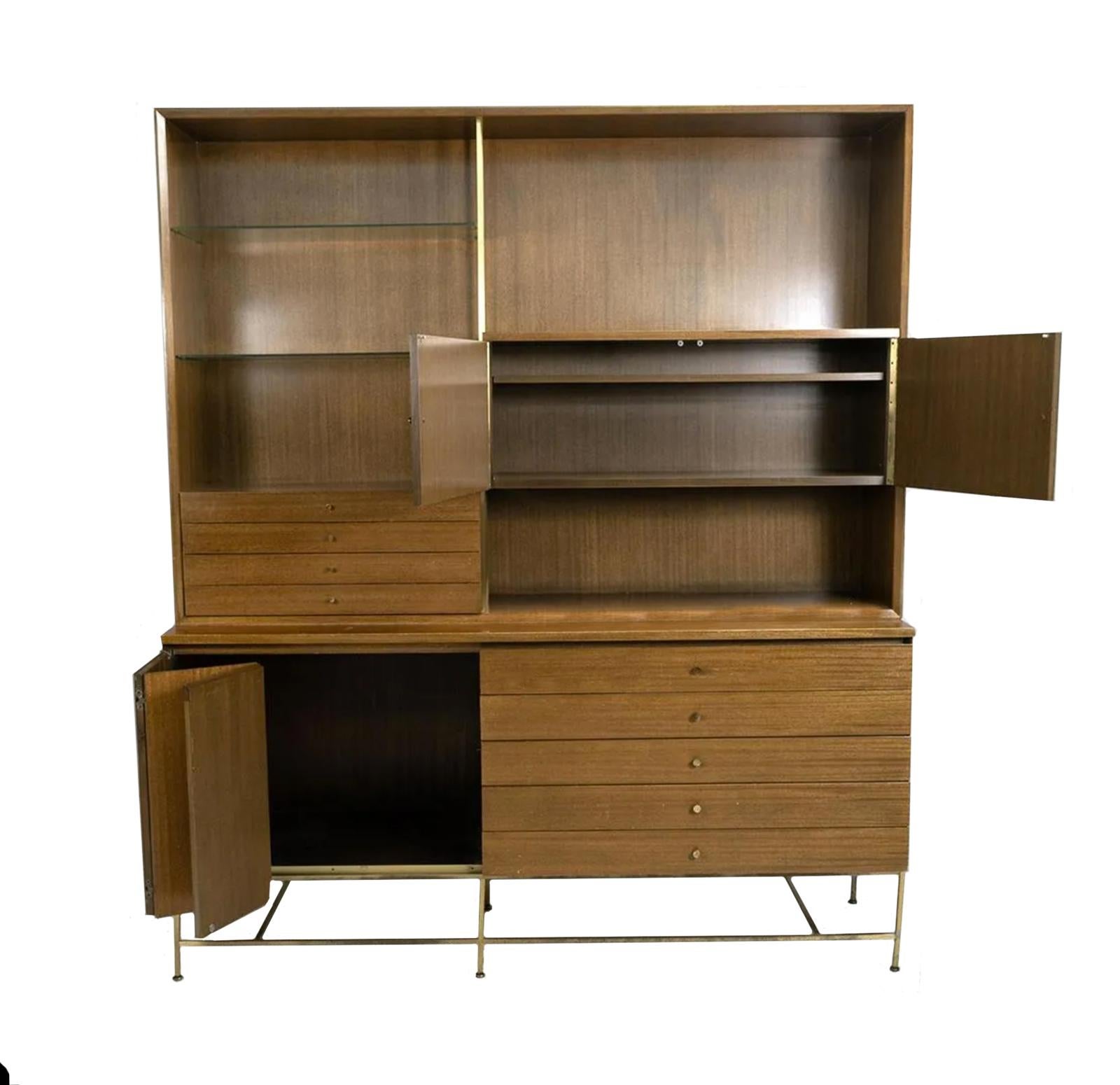 Stunning Mid century American designer Paul McCobb Wall unit with lower credenza in walnut. Original finish in good vintage condition with front folding walnut front doors and brass accents. All bleached Walnut brown finish with a brass accents.