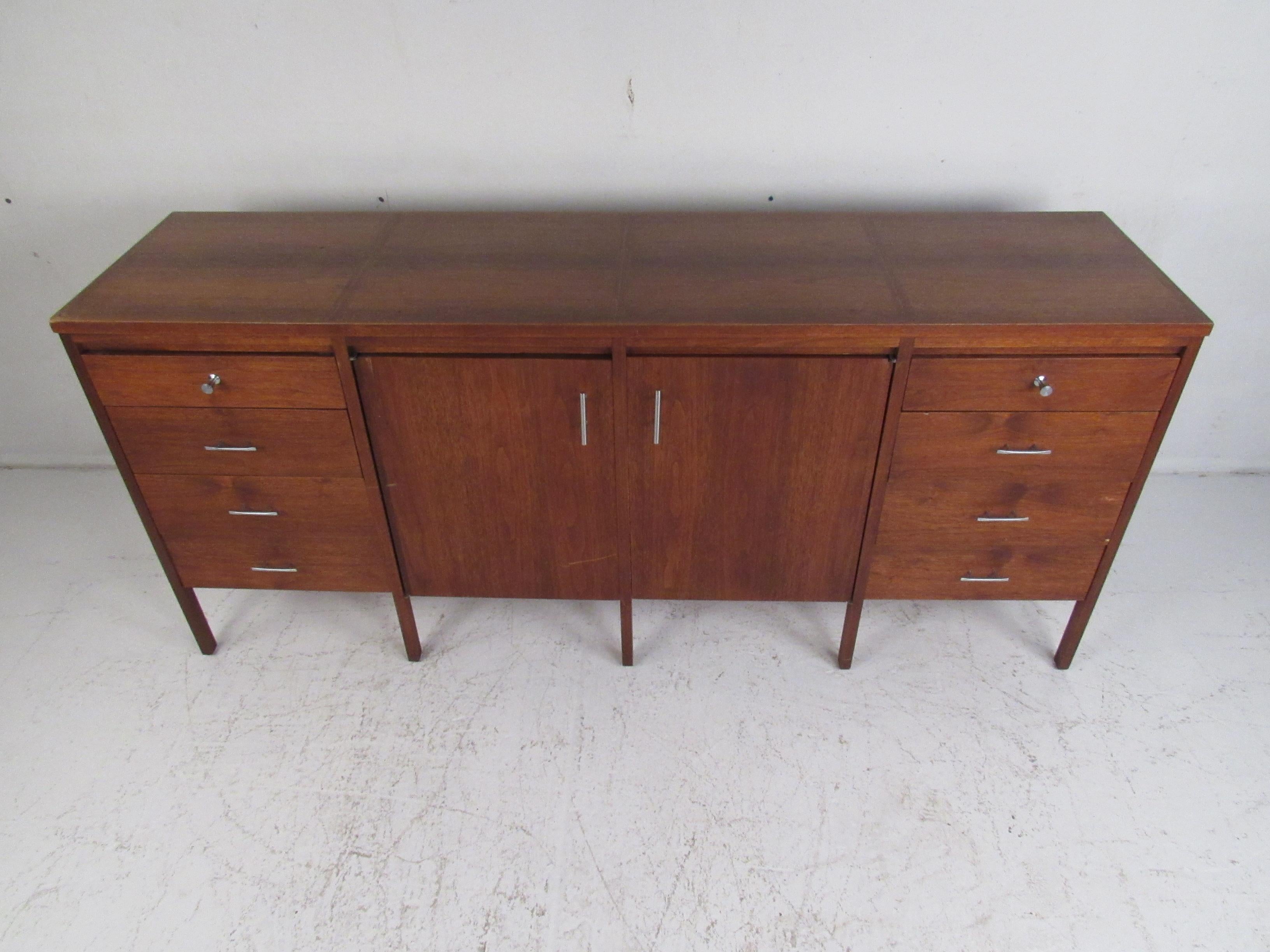 This beautiful vintage modern dresser boasts sixteen hefty drawers ensuring plenty of room for storage within its compact design. A stylish case piece with cabinet doors in the center hiding additional storage. Quality craftsmanship with vertical