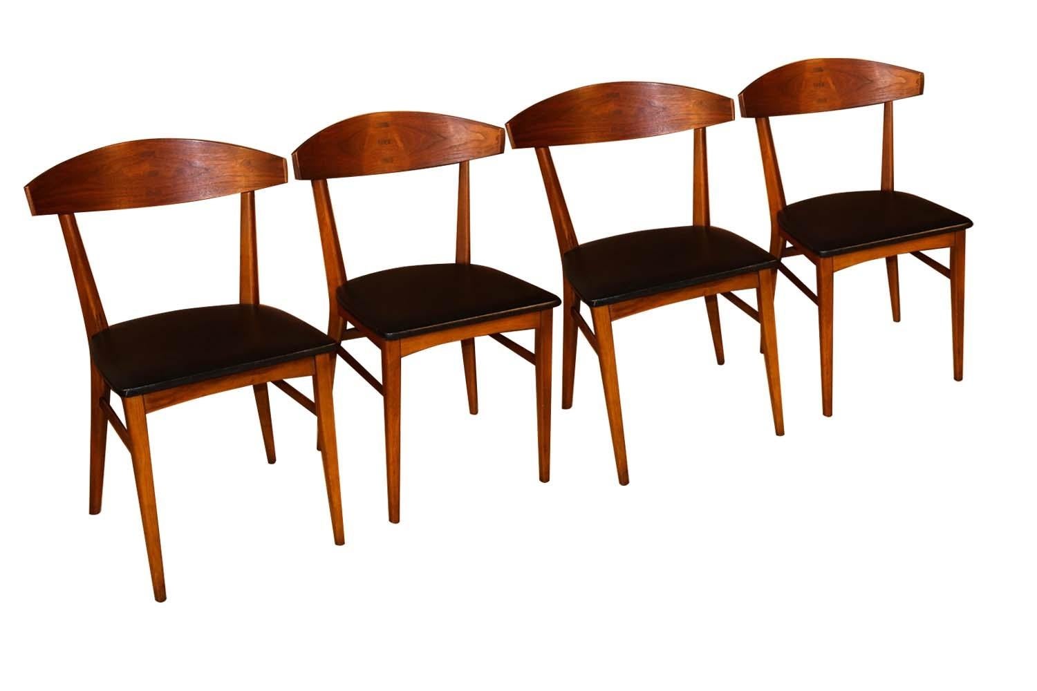 Incredibly well constructed set of four Paul McCobb dining chairs from the Components line of Lane Furniture. This beautiful rare set of walnut dining chairs designed by Paul McCobb in 1962 feature a graceful concave back rest with a centered cross