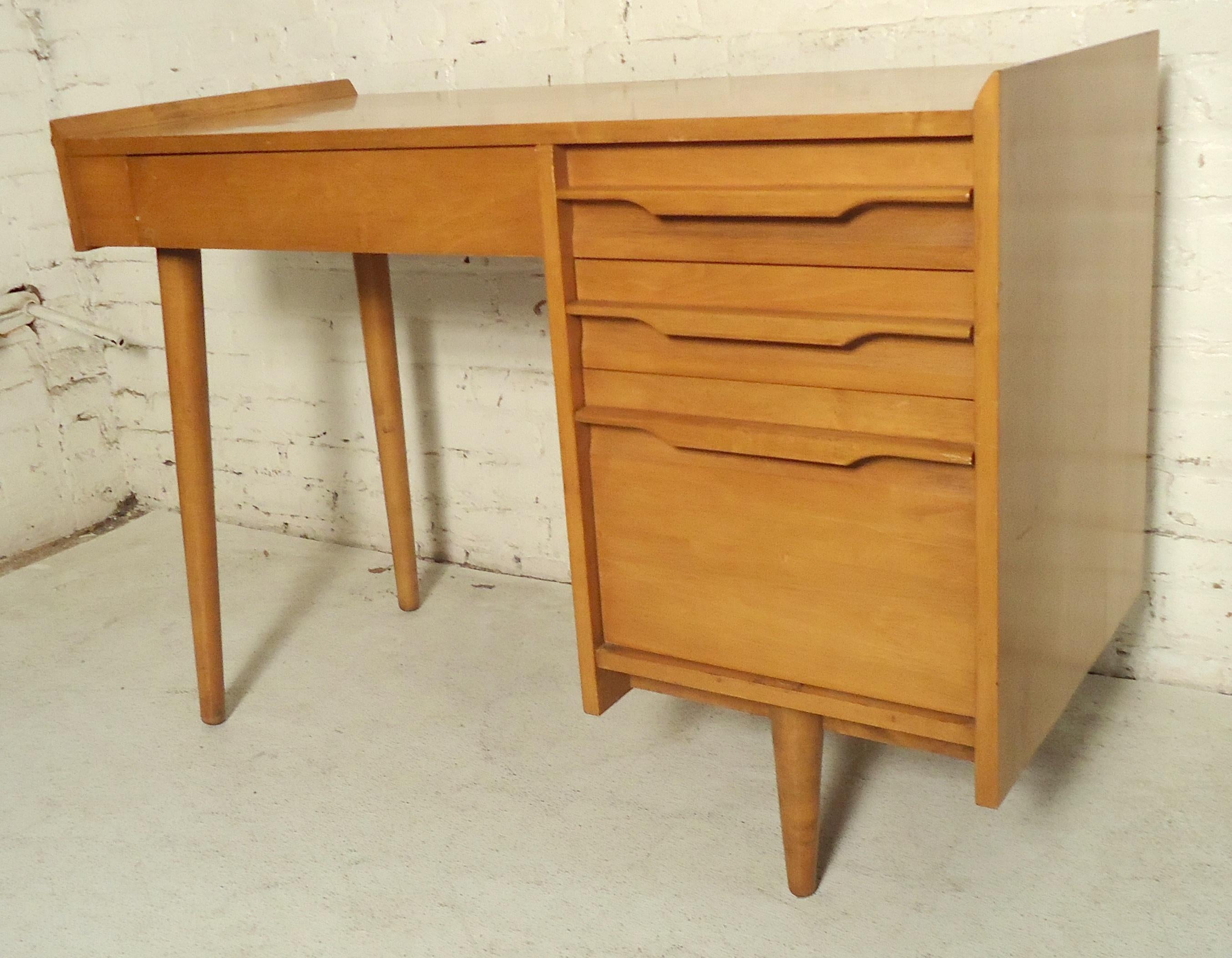 Stylish vintage modern maple desk with flared edges and sculpted handles. Tapered legs, four total drawers.

(Please confirm item location - NY or NJ).
 