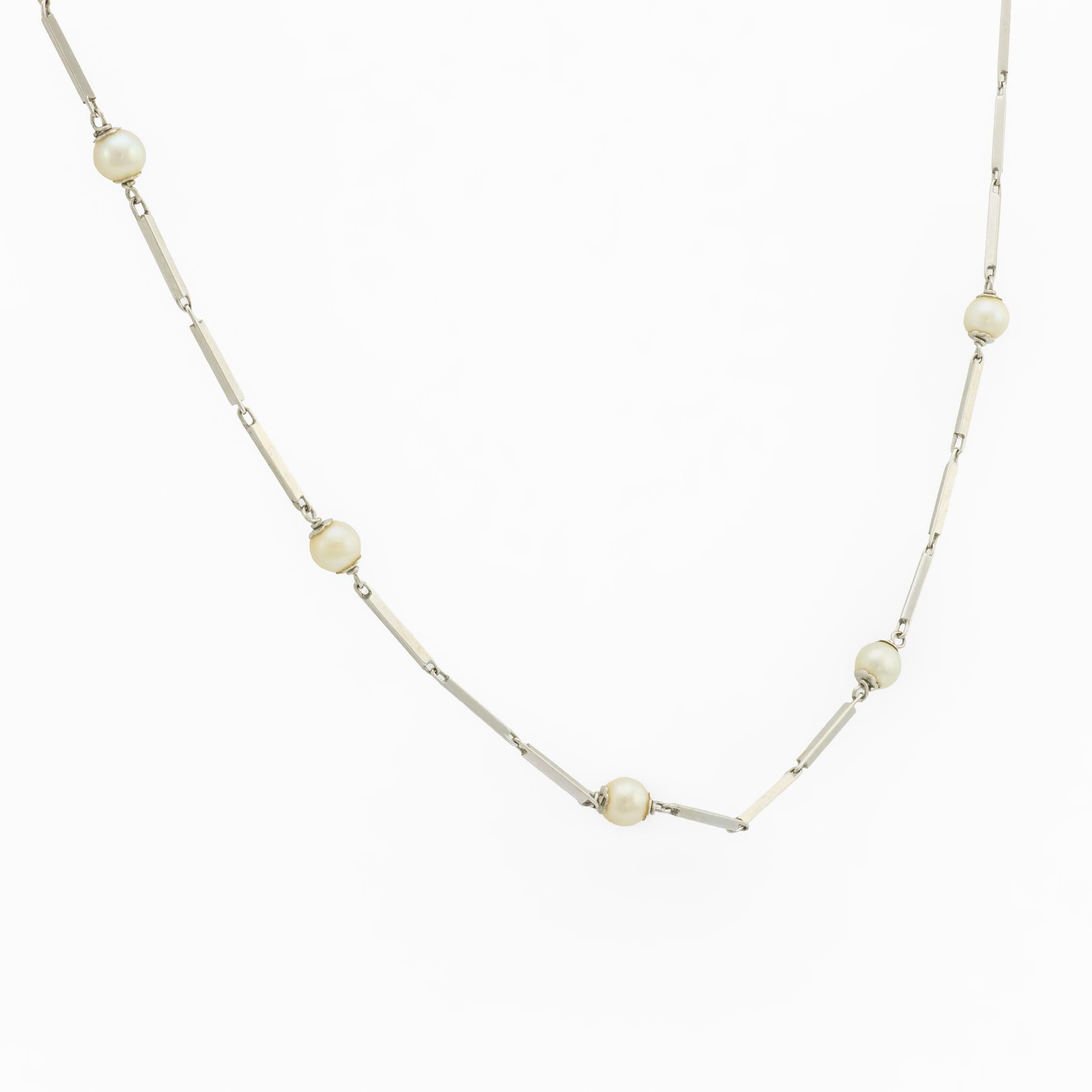 Elegante e raffinata, questa collana Mid Century incarna la sobria raffinatezza degli anni Sessanta. Diciotto luminose perle coltivate sono graziosamente distanziate lungo un'elegante catena a maglie in oro bianco 18 carati, la cui morbida