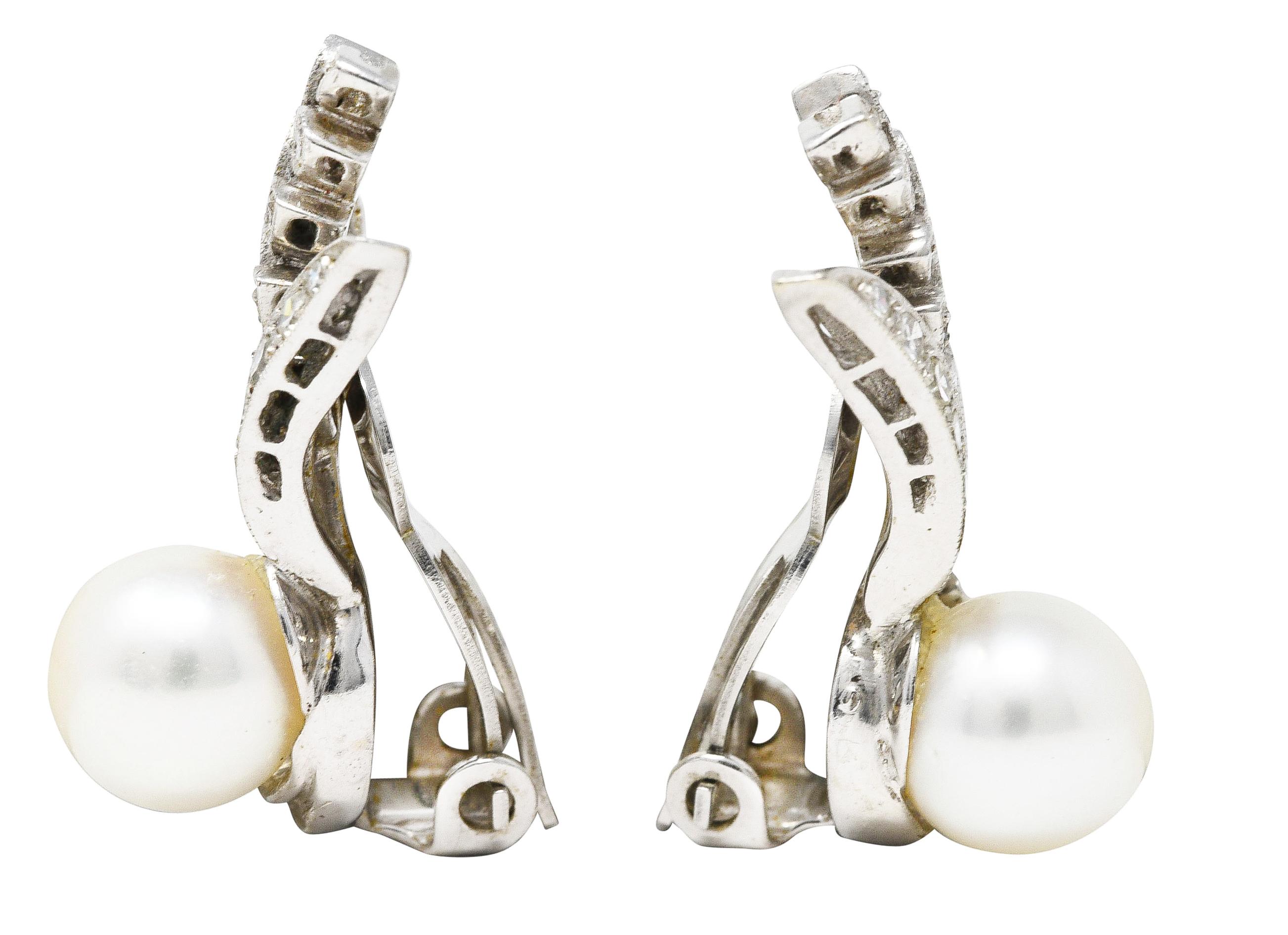 Ear-clip earrings are designed as fanning foliate motif featuring 8.0 mm round pearls. White in body color with good luster. Accented by single cut diamonds pavè set throughout. Weighing approximately 0.76 carat total - H/I in color with VS2