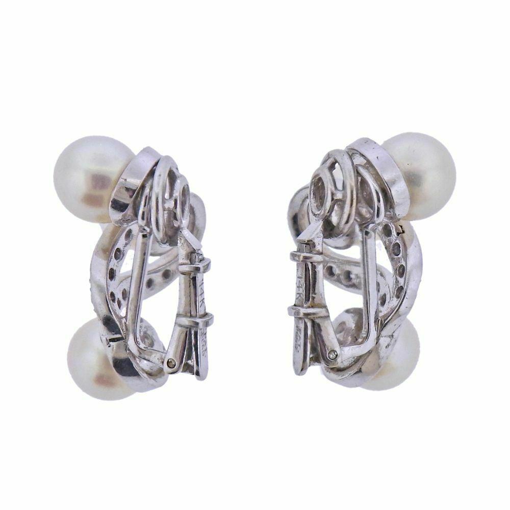 Pair of 14k white gold earrings featuring 7mm pearls and approx. 0.40ctw of H-I SI1 diamonds. Earrings measure 25mm x 16mm. Marked 14k, Pat. Pend. Weight is 9.9 grams. 