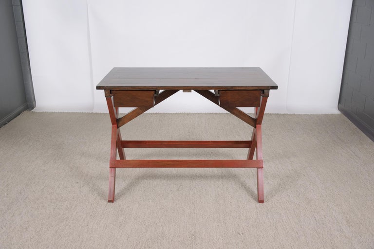 An extraordinary mid-century pine desk in good condition beautiful hand-crafted out of solid pitch pine wood newly restored by our team of craftsmen. This 1950s desk features a rectangular wood slab top with wear & use from age, is newly stained in