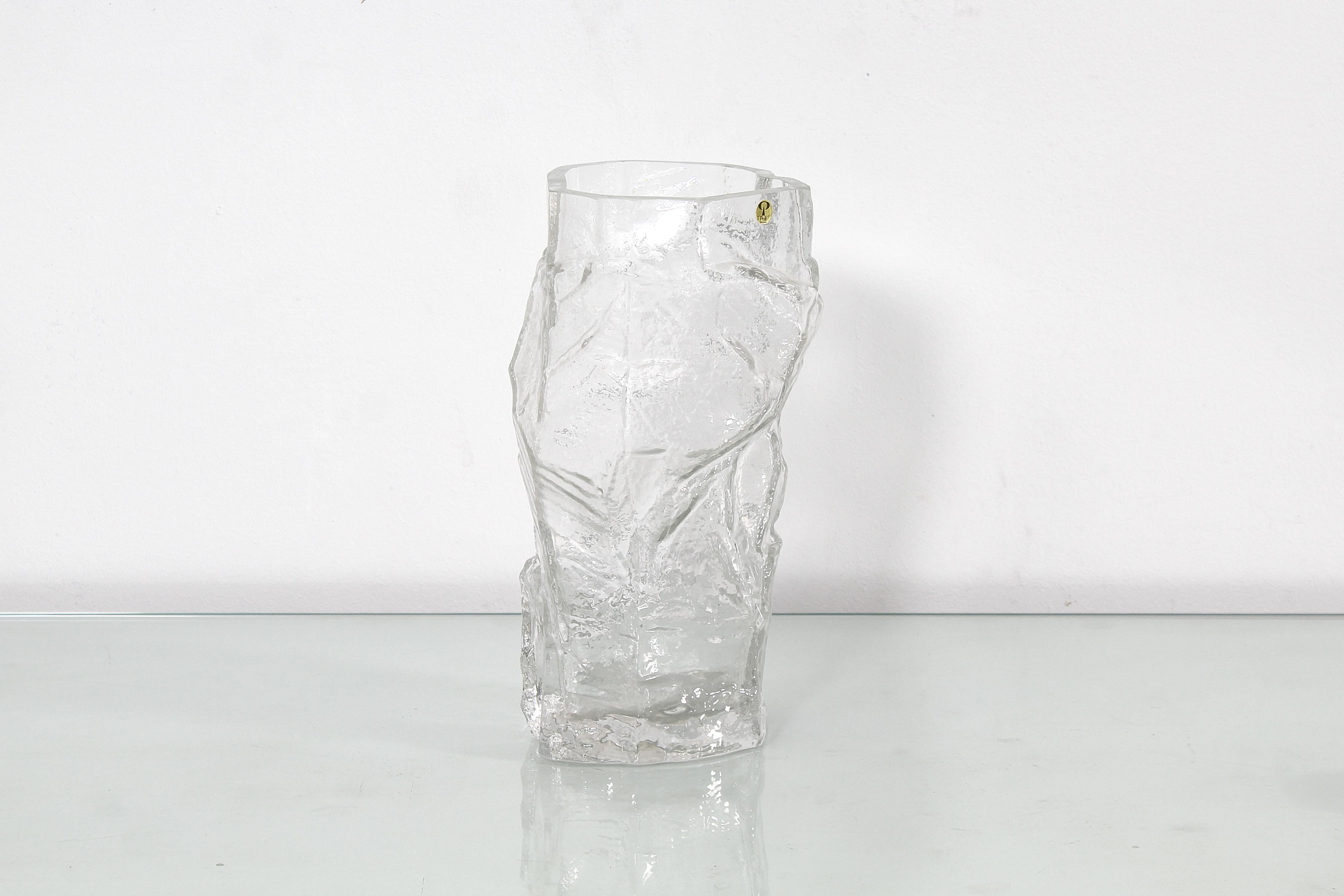 Beautiful and unusual thick and heavy 'glacier' clear glass vase, with an irregular shape, made by Peill & Putzler of Germany. in 1970s. Manufacturer's label near the edge. 
Wear consistent with age and use.