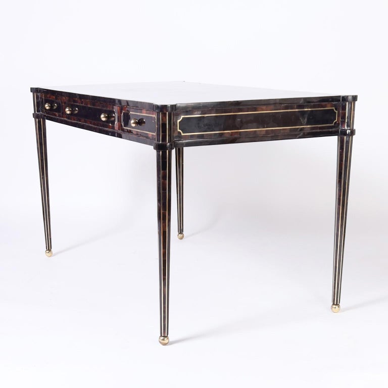 Chic sleek Mid-Century Modern desk crafted in a pen shell mosaic with three drawers in the case having brass highlights on elegant legs with ball feet. Signed Maitland-Smith in drawer.