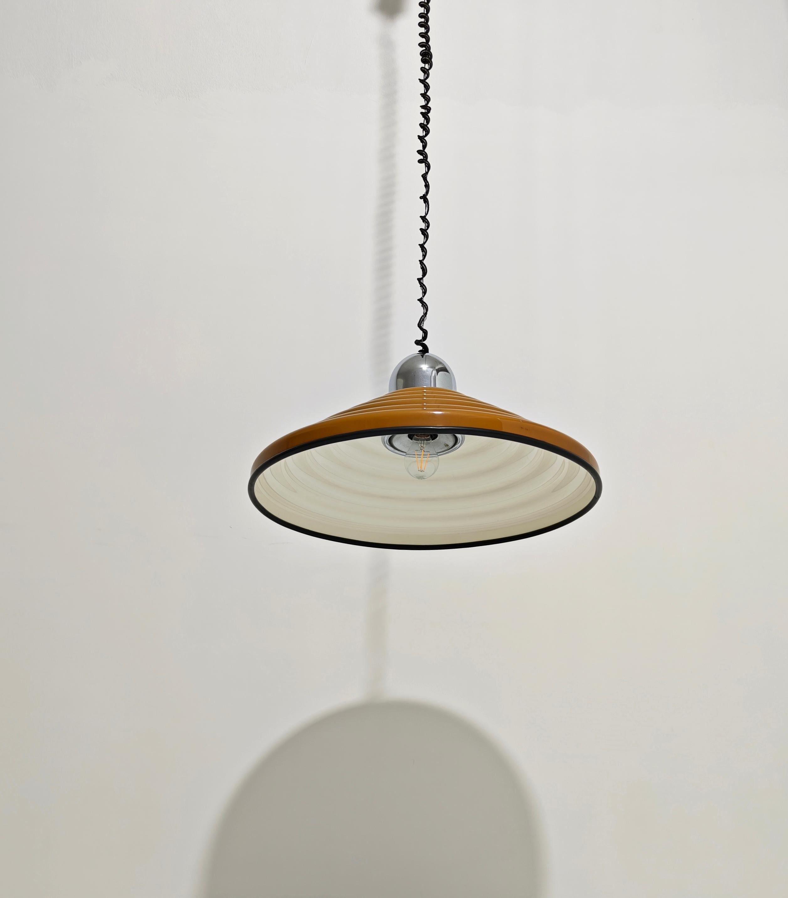 Sospensione marrone  paralume a cono nervato in perspex. Produzione Harvey Guzzini, Italia, anni '70. Bordo in gomma nera. Portalampada e rosone da soffitto cromati. La sua altezza può essere regolata in base alle tue esigenze.  Ti preghiamo di