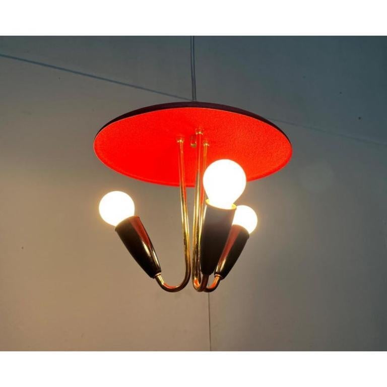 Imposante Mid Century-Hängeleuchte in einer besonderen Farbe.

Der Kontrast von Rot und Schwarz ist auffallend. Der extrem gute Zustand der Originalfarben, die den flachen Schirm und den schwarzen Dom auf der Oberseite als Strukturlack abdecken.