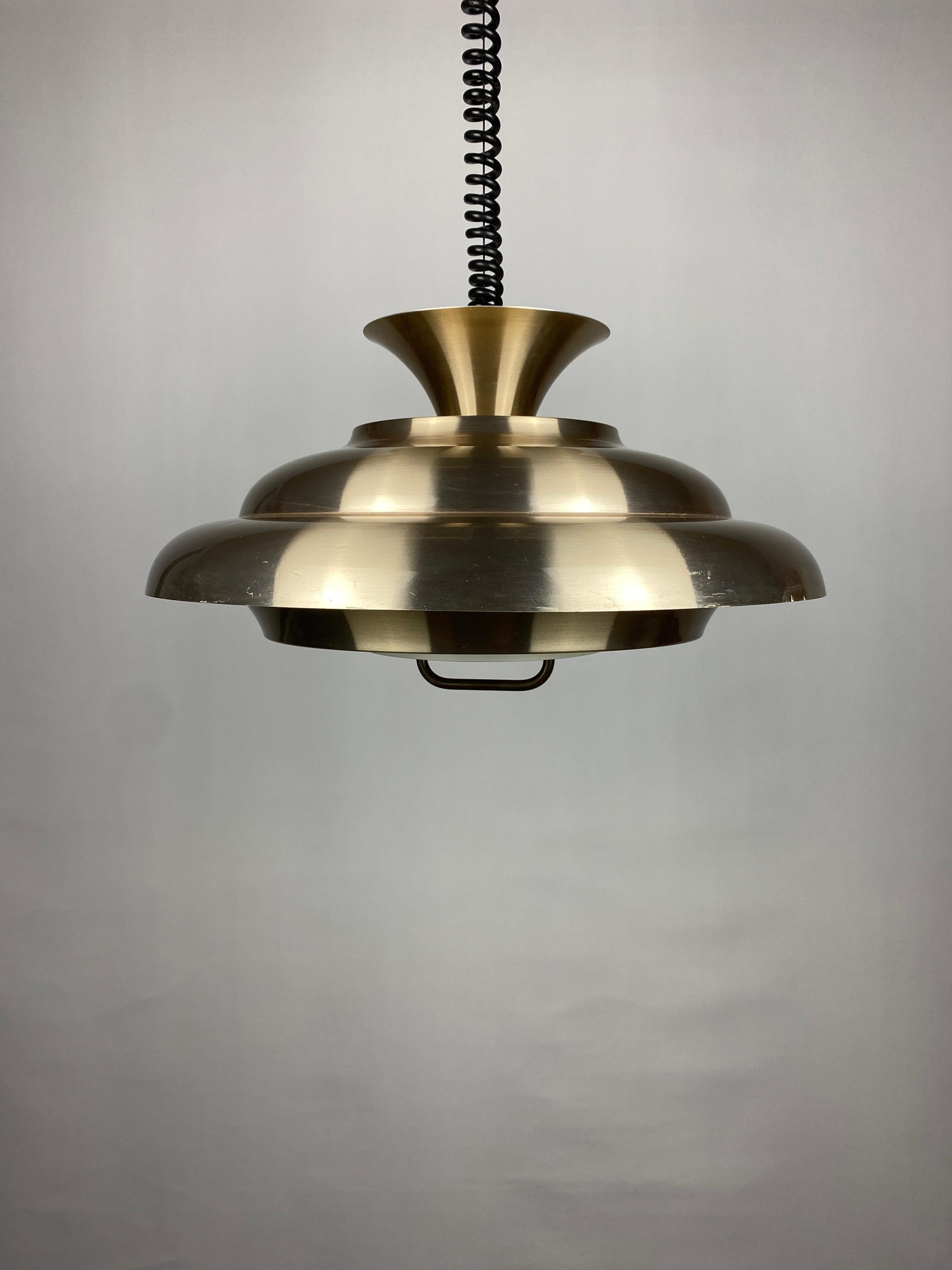 Cool pendant lamp produced by Dijkstra, made in Holland from the 1960s - 1970s. 

The lamp made of aluminum consists of different slats, creating a beautiful light. The lamp is extendable to approximately 140 cm and also rolls back up smoothly with