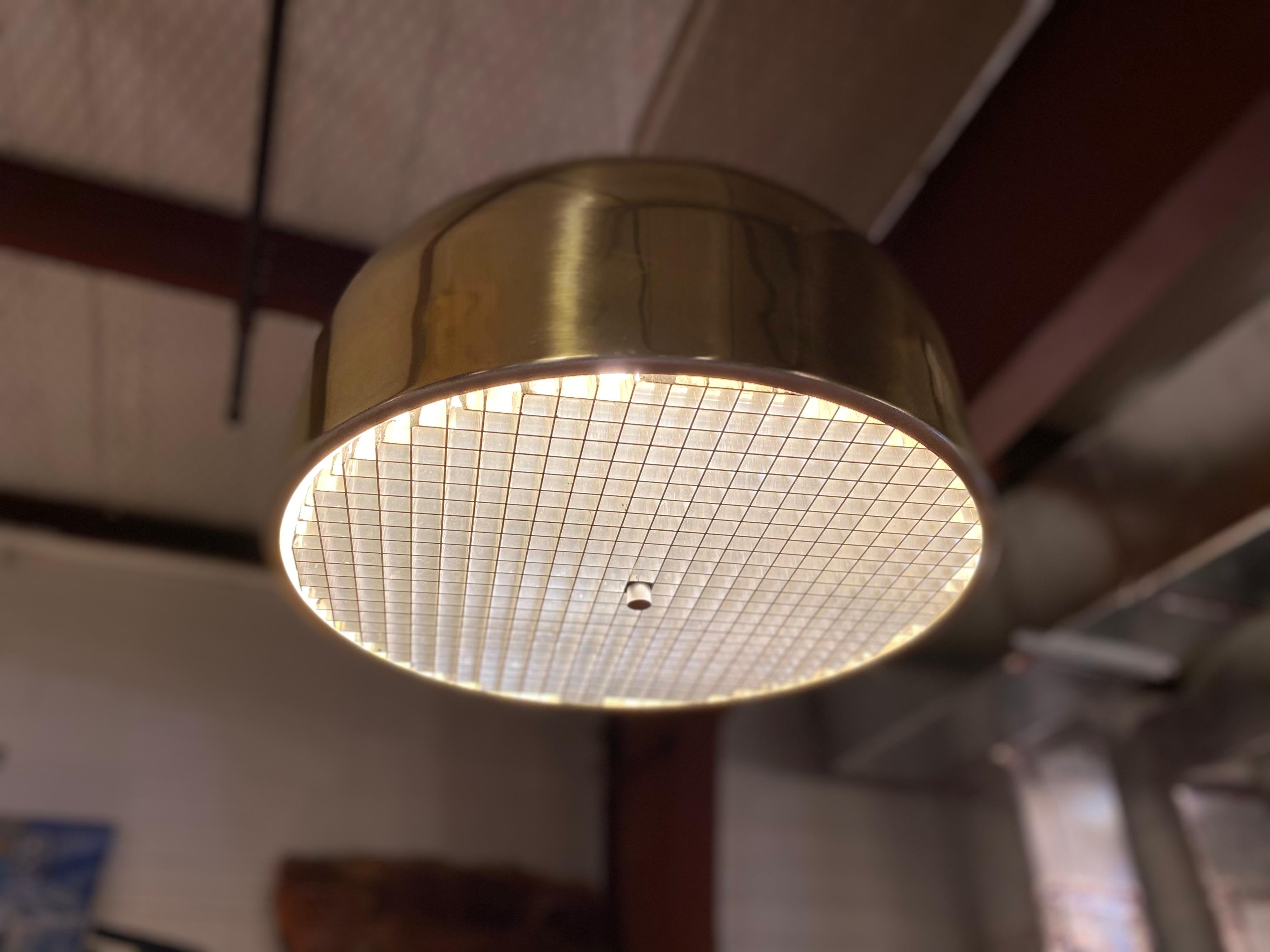 Magnifique lampe à suspension de Lightolier, fabriquée en laiton et dotée d'un diffuseur à lentille épaisse. Ce luminaire suspendu du milieu du siècle est en excellent état général.
