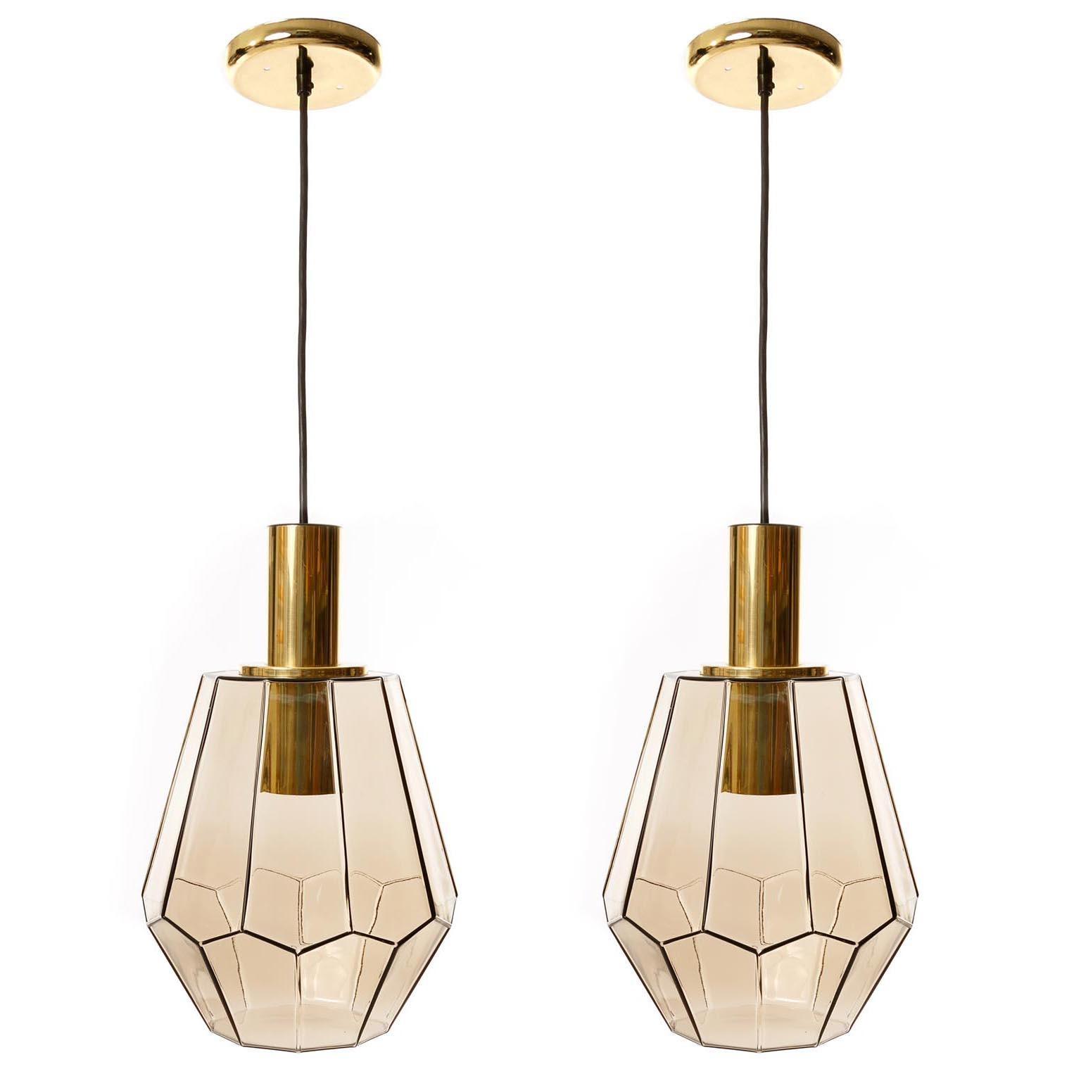 One of two brass and hand blown glass pendants by Glashütte Limburg, Germany, manufactured in midcentury, circa 1970.
The suspension and canopy are made of polished brass. The glass lamp shade is in a smoke / amber / topaz or brown amethyst