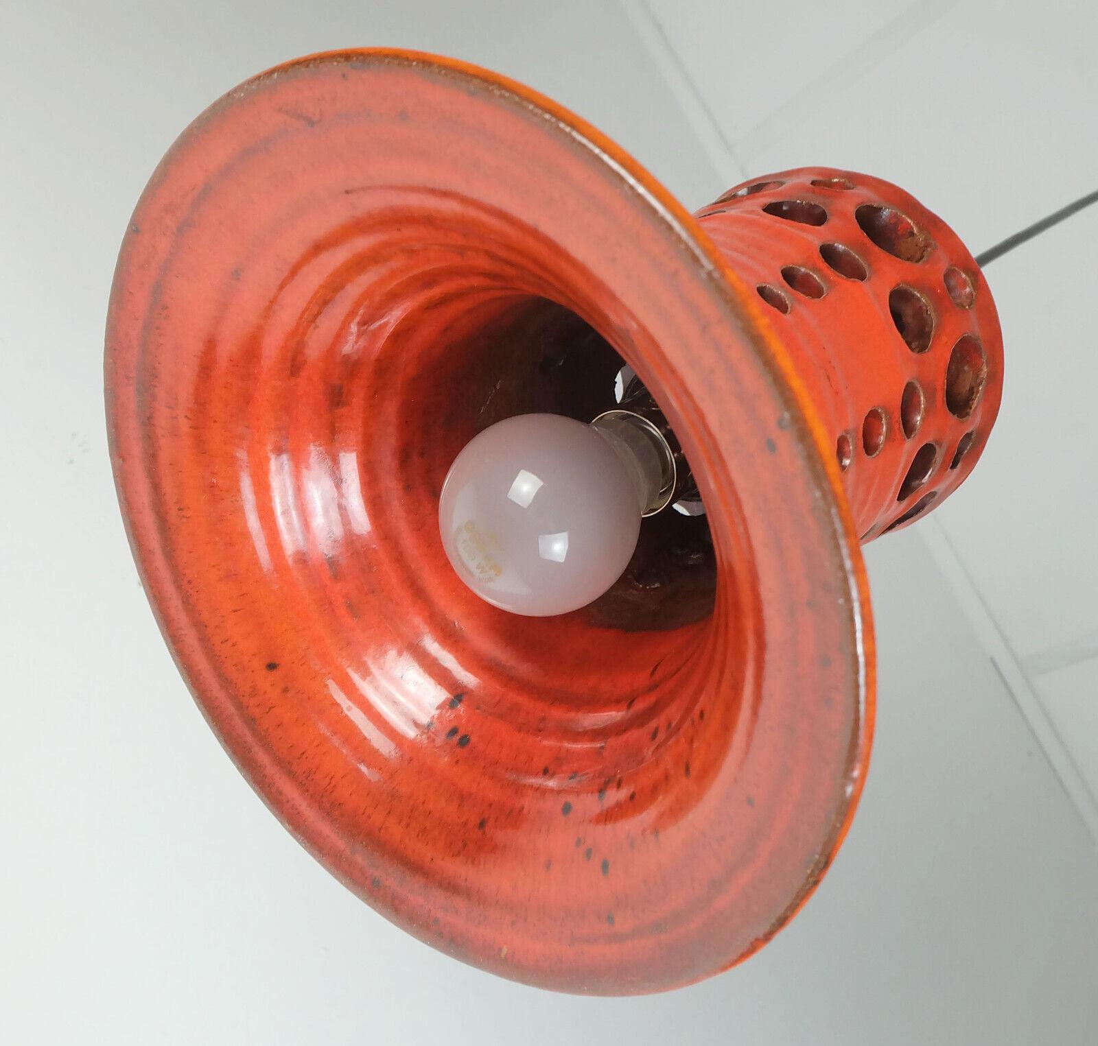 Very beautiful 1970s pendant light. The shade is made of orange glazed ceramic with some red and black. The hole structure creates an interesting light effect and a cozy atmosphere. Black electric wire and black canopy. Holds 1 E27 light