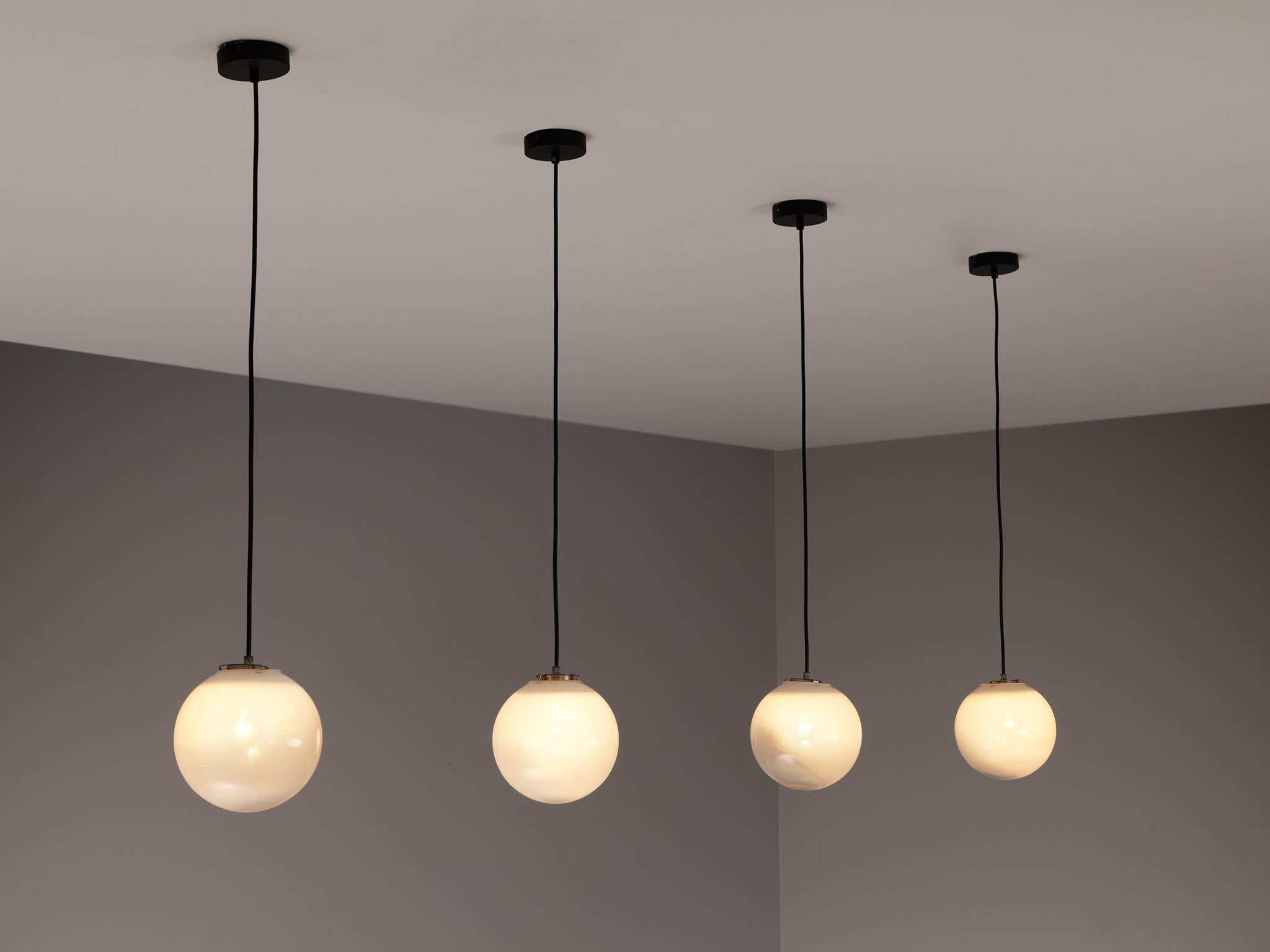 Pendants, glass, metal, plastic, Europe, 1960s.

These atmospheric pendant lamps features each an opaque to clear glass orb. This results in a nice and soft light-tone creating a lively ambience in the room. The lamps can be hung above a large
