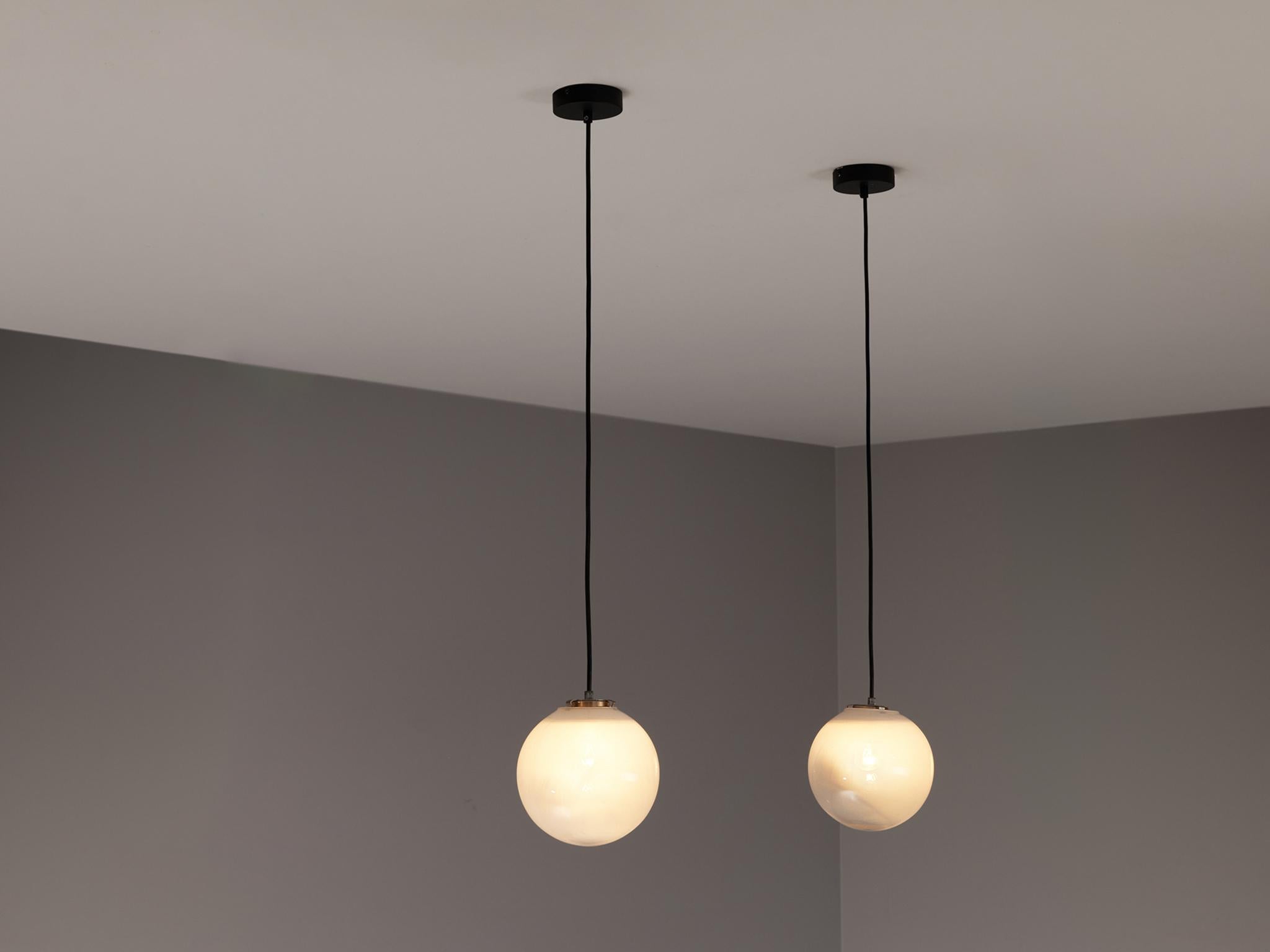 Pendentifs, verre opalin, métal, Europe, années 1960.

Ces lampes suspendues atmosphériques sont dotées d'un orbe en verre opalin ou transparent. Il en résulte une lumière douce et agréable qui crée une ambiance vivante dans la pièce. Les lampes