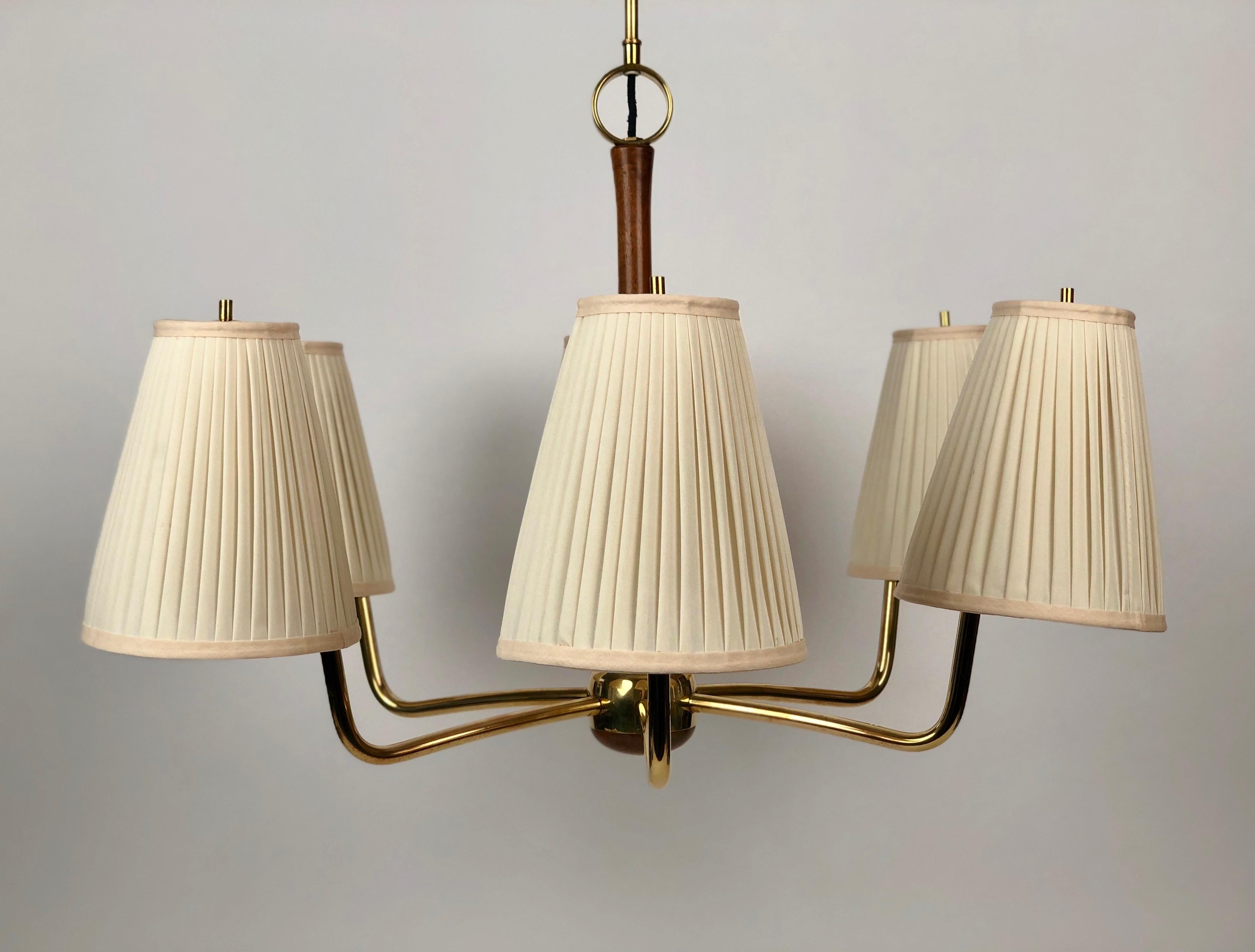 A beautiful mid-century chandelier  from Josef Frank. This six arm lamp is made of
brass with walnut accents. The combination of the walnut with the brass makes
this piece very sublime.

The shades have been recovered in silk using the original