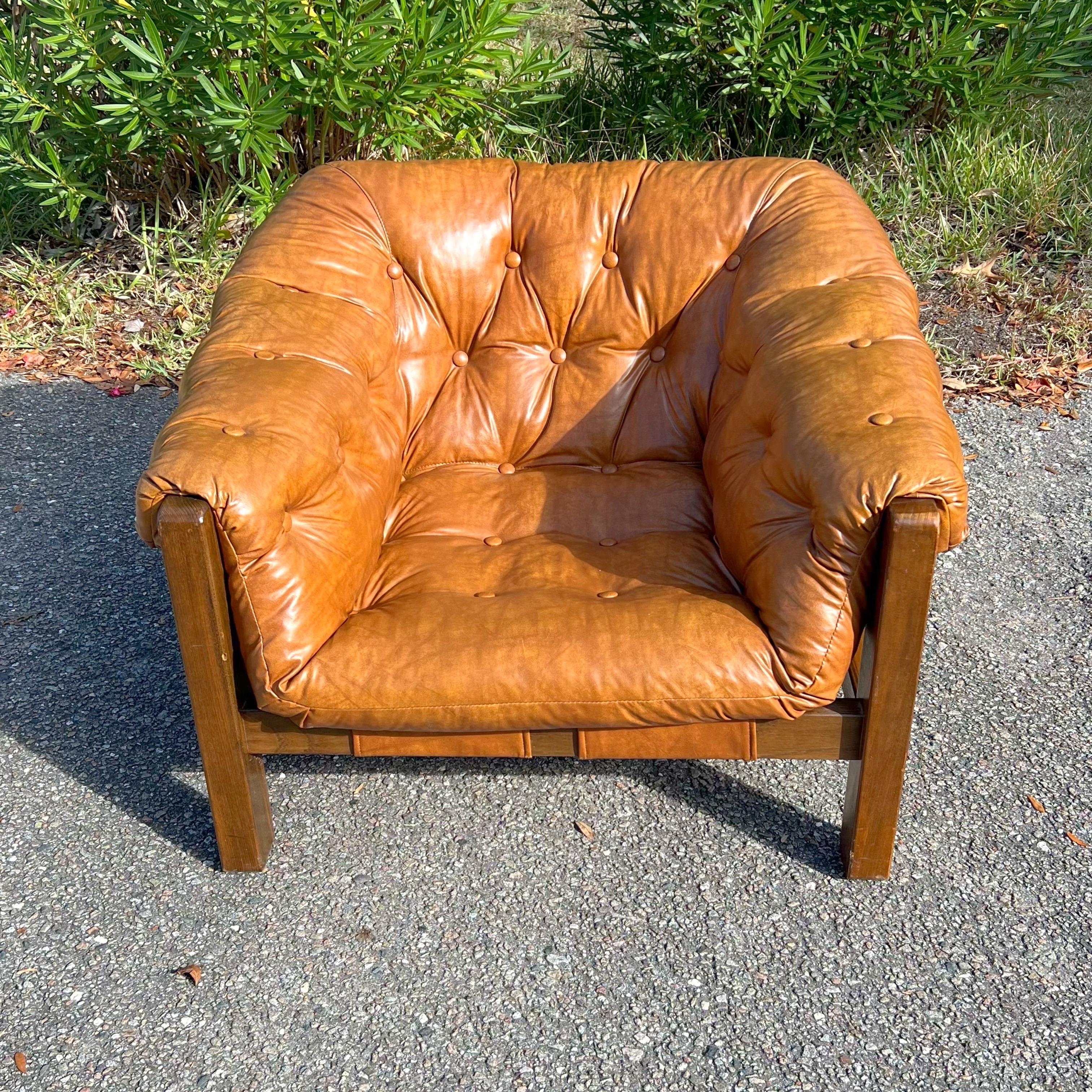 Stunning leather armchair in manner of Brazilian designer Percival Lafer.  Featuring a solid wood frame with beautiful grain that supports the natural leather straps which the tufted leather cushion rests on.  The original leather upholstery in very