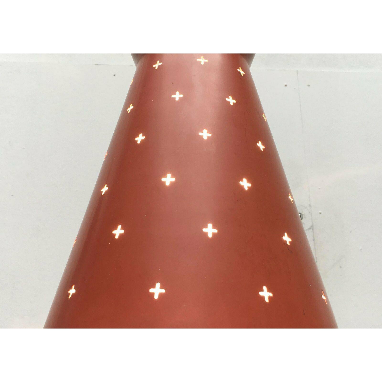 Lampada a sospensione di metà secolo con una suggestiva perforazione a croce. Il design è spesso attribuito al produttore italiano Stilnovo. Probabilmente è di origine tedesca e proviene da Hillebrand.

L'ombrello ha una semplice forma a diabolo. La